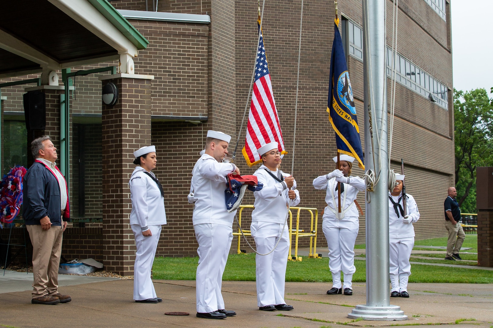 The Norfolk Naval Shipyard Flag Detail, alongside Gold Star Family Member and Veterans Employee Readiness Group member Glenn Branchaud, raises the flag during the Memorial Day Fall-In for Colors May 25.