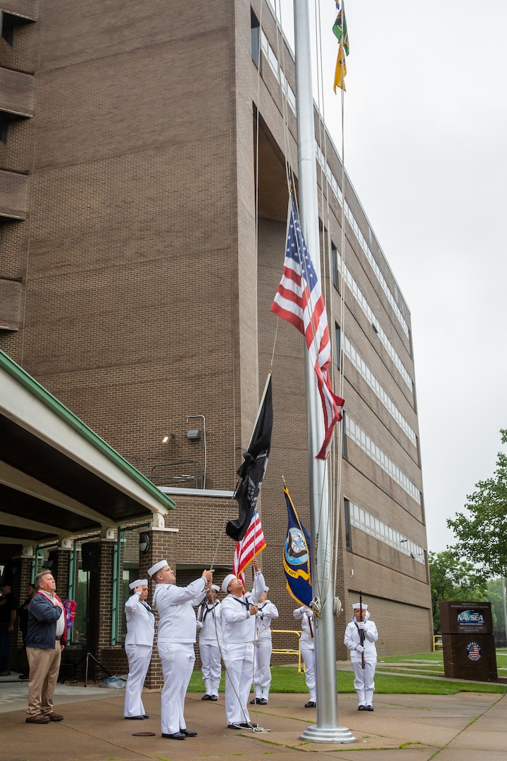 The Norfolk Naval Shipyard Flag Detail, alongside Gold Star Family Member and Veterans Employee Readiness Group member Glenn Branchaud, raises the flag during the Memorial Day Fall-In for Colors May 25.