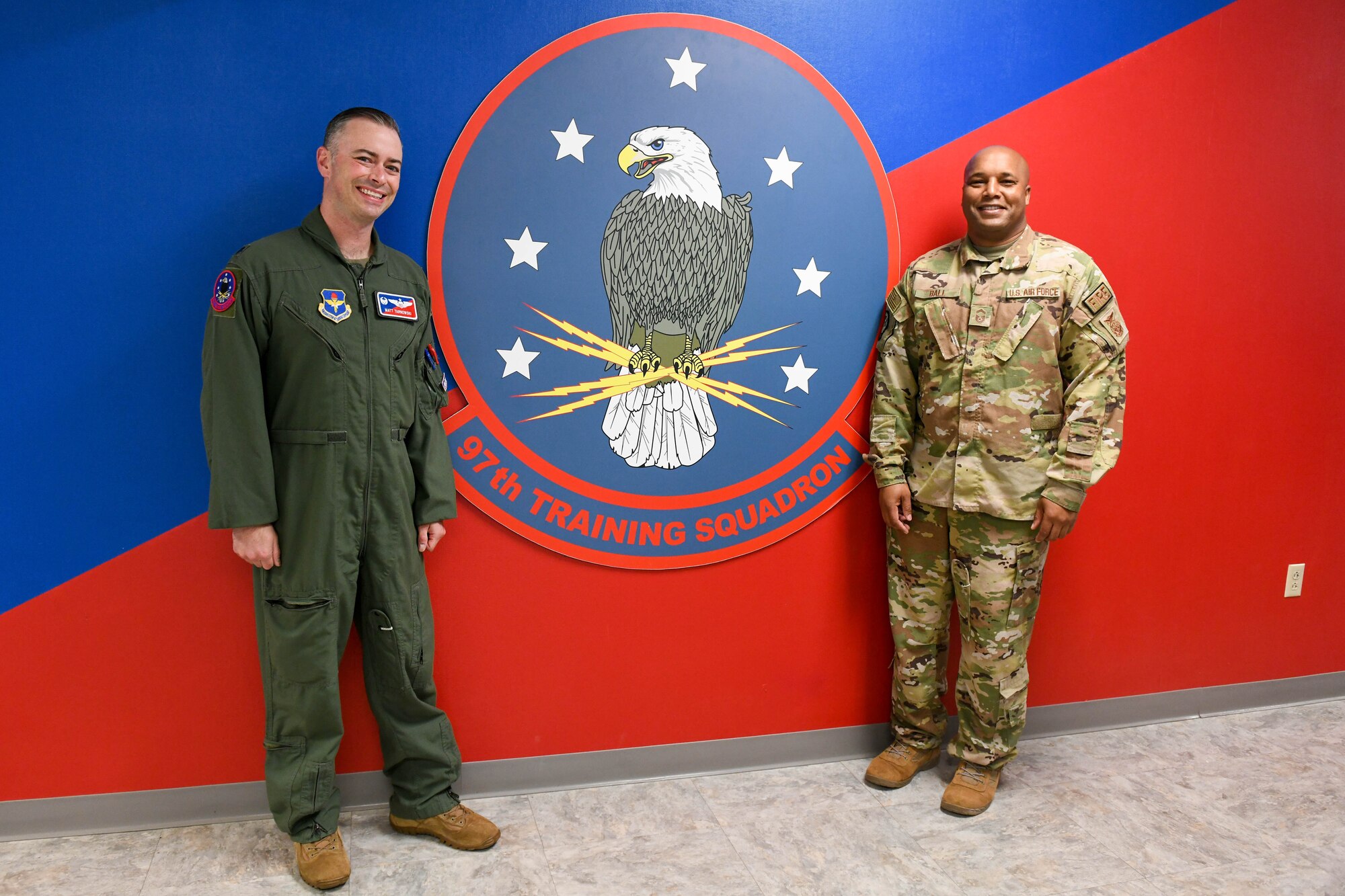 U.S. Air Force Lt. Col. Matthew Tarnowski, 97th Training Squadron (TRS) commander, and Senior Master Sgt. Byron Ball, 97th Civil Engineer Squadron deputy fire chief, pose for a photo at Altus Air Force Base, Oklahoma, May 24, 2022. Ball was the first sergeant of the 97th TRS before deploying to Al Jaber Air Base, Kuwait and Al Udeid Air Base, Qatar. (U.S. Air Force photo by Airman 1st Class Trenton Jancze)