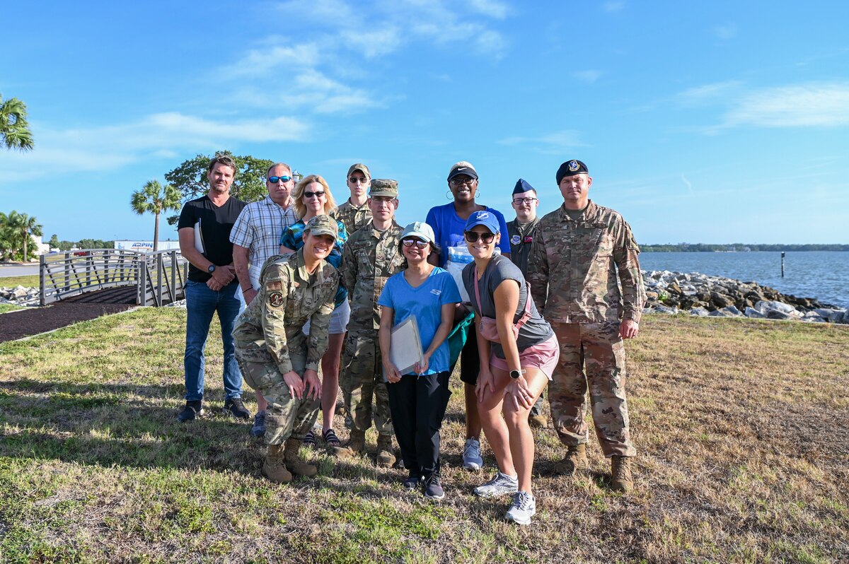 U.S. Airmen and volunteers from the surrounding community pose for a photo after placing memorial ribbons on lamp posts during the Second Annual Memorial Day Remembrance Event at MacDill Air Force Base, Florida, May 25, 2022.
