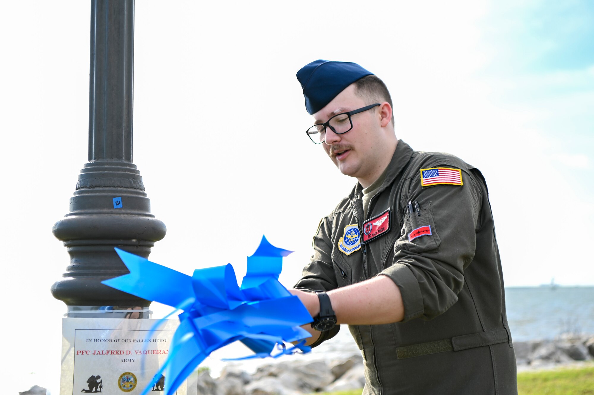 U.S. Air Force Airman 1st Class Alex Fiscus, a boom operator with the 50th Air Refueling Squadron, ties a bow during the Second Annual Memorial Day Remembrance event at MacDill Air Force Base, Florida, May 25, 2022.