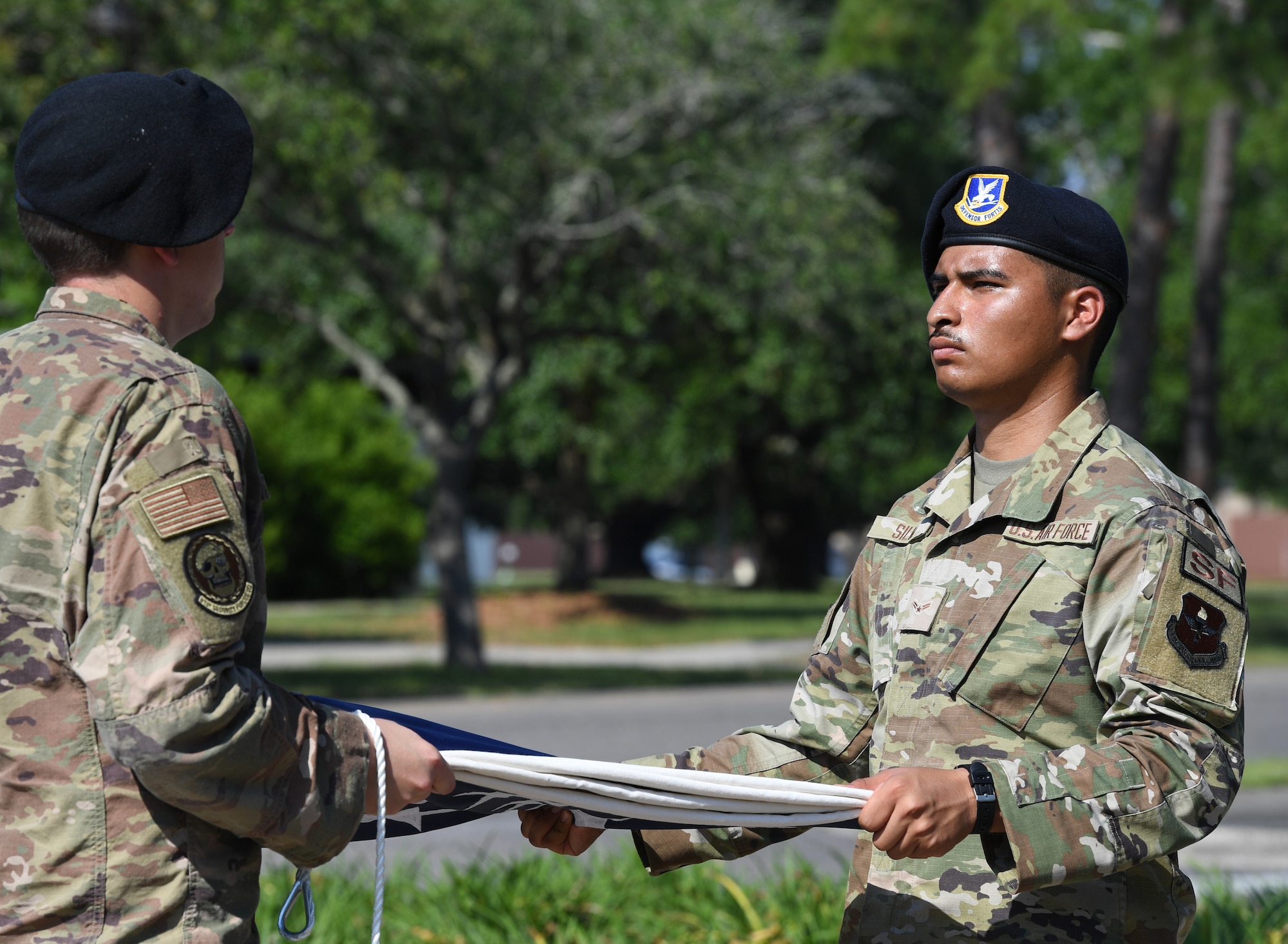 U.S. Air Force Staff Sgt. Jacob Jettmar, 81st Security Forces Squadron base defense operations center controller, and Airman 1st Class Angel Silva, 81st SFS entry controller, participate in a retreat ceremony at Keesler Air Force Base, Mississippi, May 20, 2022. The ceremony, hosted by the 81st SFS, was the last of several events held in celebration of this year's Police Week. (U.S. Air Force photo by Kemberly Groue)