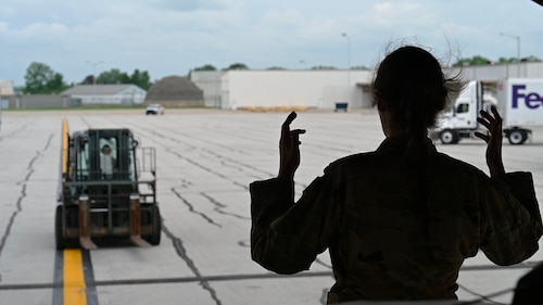 U.S. Air Force Senior Airman Joe Besse, 535th Airlift Squadron loadmaster, marshals a forklift at Indianapolis International Airport, Indiana, May 22, 2022. U.S. Transportation Command expeditiously coordinated across federal agencies, including the Departments of Agriculture and Health and Human Services and the Food and Drug Administration, to support U.S. President Joe Biden’s direction to conduct Operation Fly Formula. The mission was executed with urgency and safety by 521st Air Mobility Operations Wing Airmen stationed on Ramstein Air Base, Germany, and a Total Force aircrew stationed at Joint Base Pearl Harbor-Hickam, Hawaii, currently staged at Ramstein AB. (U.S. Air Force photo by 1st Lt. Emma Quirk)
