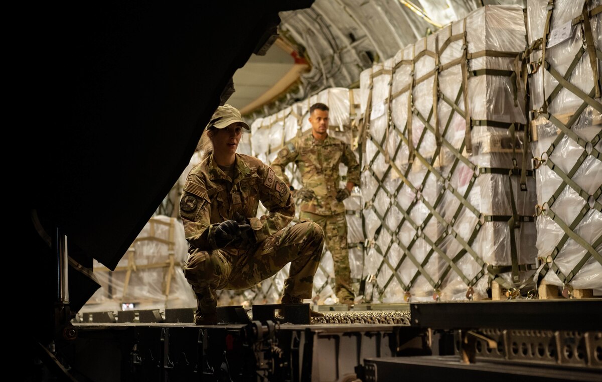Senior Airman Jolan Besse, 721st Aerial Port Squadron loadmaster, assists Airmen as they load infant formula onto a C-17 Globemaster lll aircraft assigned to Joint Base Pearl Harbor-Hickam, Hawaii, at Ramstein Air Base, Germany, May 22, 2022. The infant formula arrived from Switzerland as part of the U.S. Government’s Operation Fly Formula to rapidly transport infant formula to the United States due to critical shortages there. Under Operation Fly Formula, the USDA and the Department of Health and Human Services are authorized to request Department of Defense support to pick up overseas infant formula that meets U.S. health and safety standards.  (U.S. Air Force photo by Airman 1st Class Jared Lovett)