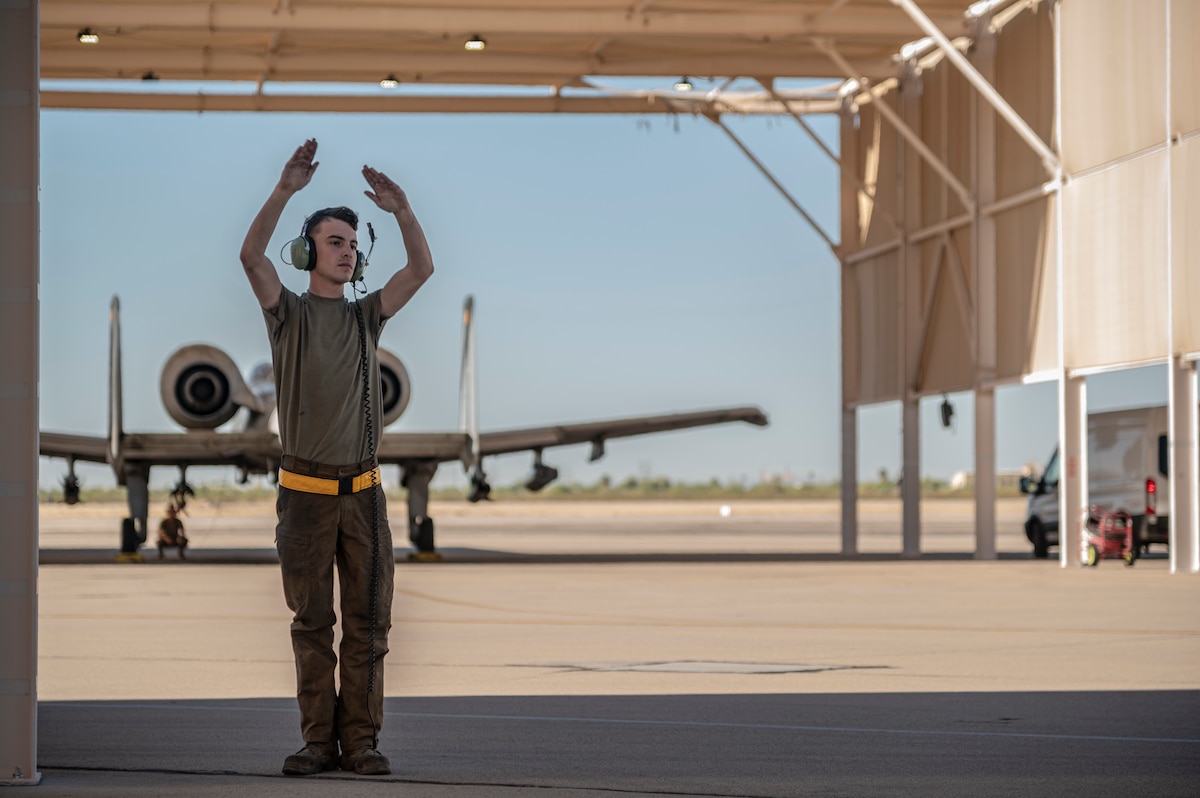 A photo of an Airman signaling an aircraft.