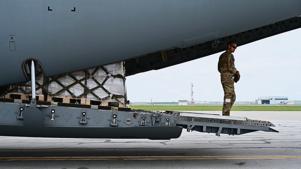 Staff Sgt. Austin Simmons, a C-17 Globemaster III loadmaster assigned to the 535th Airlift Squadron, prepares to offload 78,000 pounds of infant formula at Indianapolis International Airport, May 22, 2022. U.S. Transportation Command expeditiously coordinated across federal agencies, including the Departments of Agriculture and Health and Human Services and the Food and Drug Administration, to support U.S. President Joe Biden’s direction to conduct Operation Fly Formula. The mission was executed with urgency and safety by 521st Air Mobility Operations Wing Airmen stationed on Ramstein Air Base, Germany, and a Total Force aircrew stationed at Joint Base Pearl Harbor-Hickam, Hawaii, currently staged at Ramstein AB. (U.S. Air Force photo by 1st Lt. Emma Quirk)