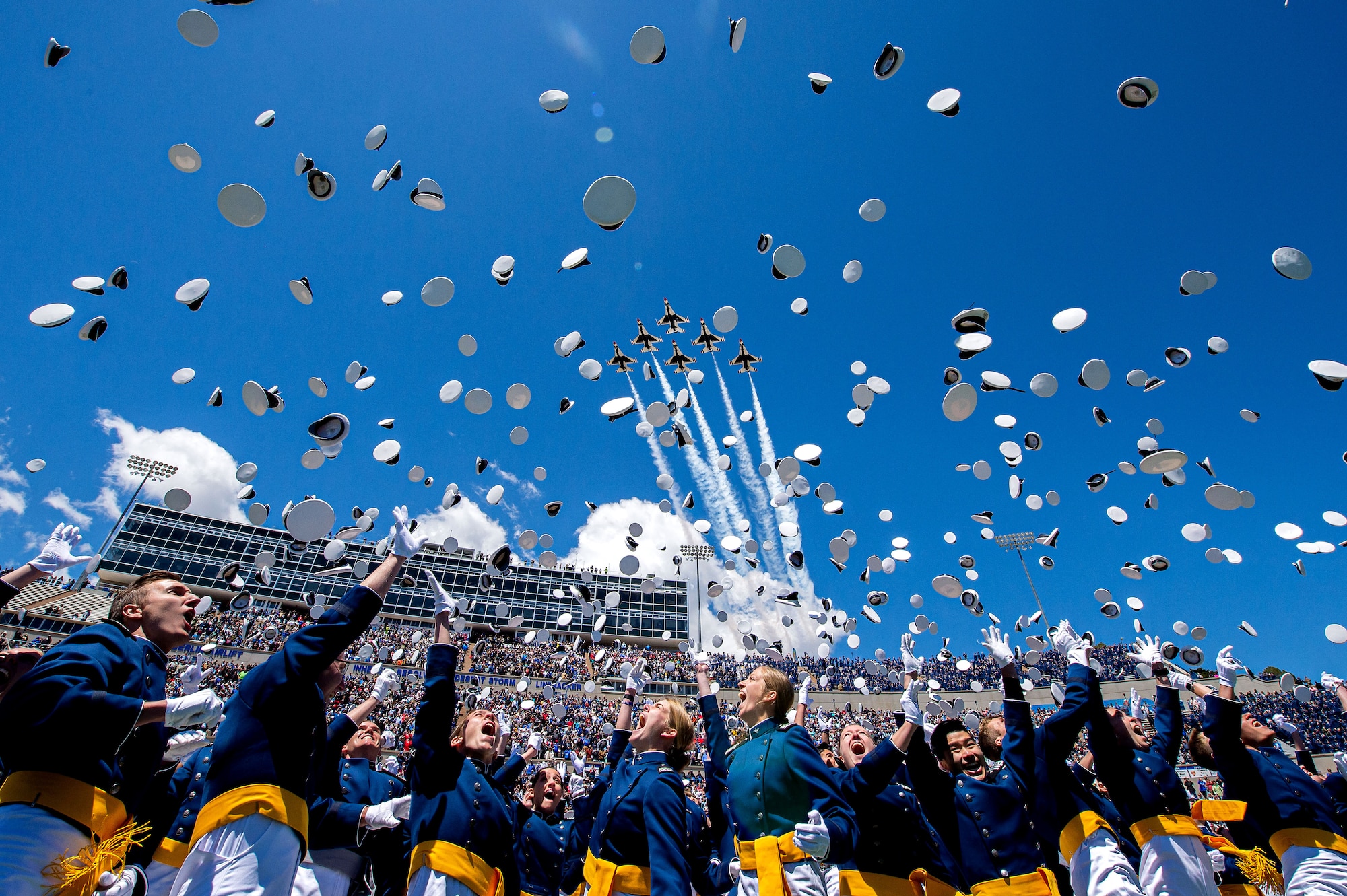 The U.S. Air Force Academy Class of 2022 graduates toss their hats into the sky as the U.S. Air Force Air Demonstration Squadron “Thunderbirds” roar overhead during the graduation ceremony in Colorado Springs, Colo., May 25, 2022. Nine-hundred-seventy cadets crossed the stage to become the Air Force and Space Force’s newest second lieutenants. (U.S. Air Force photo by Trevor Cokley)