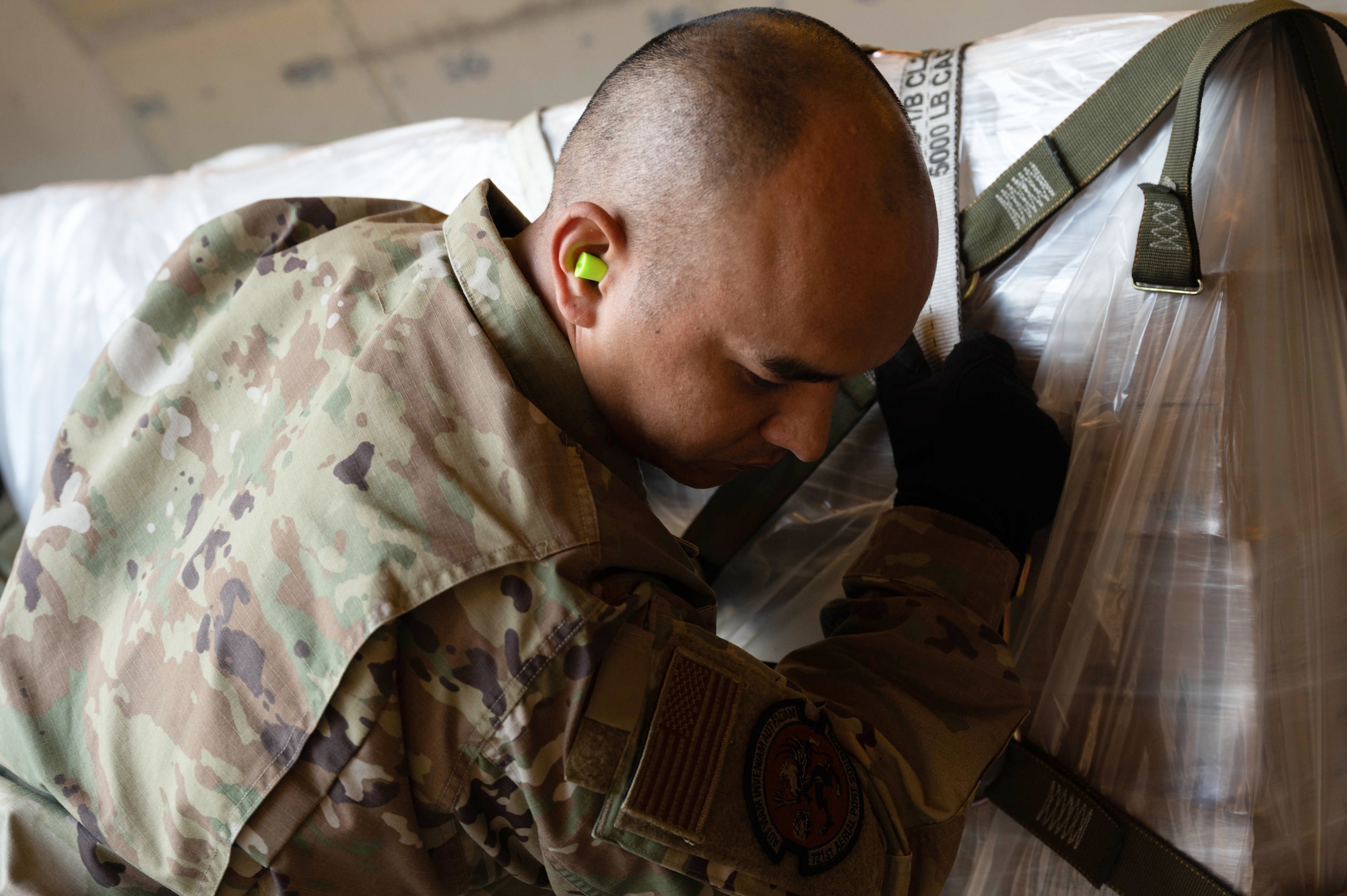 An Airman pushes a pallet of infant formula into a commercial aircraft.