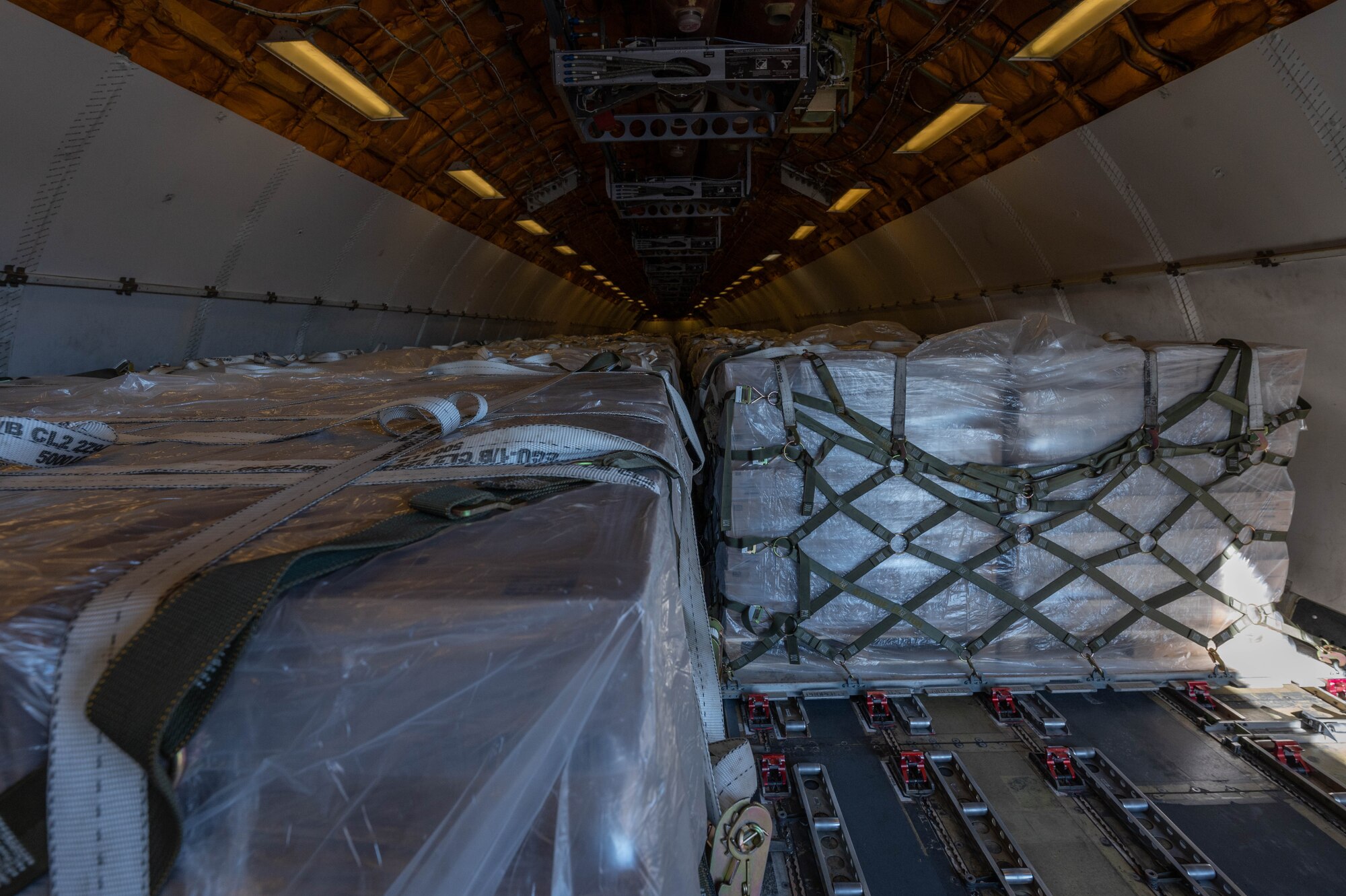 Pallets of infant formula sit inside a commercial aircraft.