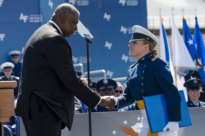 Secretary of Defense Lloyd J. Austin III  shakes hands with a cadet.