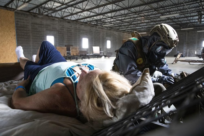 U.S. Marines with Alpha Company, Chemical Biological Incident Response Force (CBIRF), conduct proper decontamination procedures after extracting notional casualties from a simulated nuclear detonation training area during Scarlet Response 2022 at Guardian Centers of Georgia, Georgia, May 19, 2022. CBIRF Marines will bring casualties to decontamination tents, decontaminate and move them into a clean area for advanced medical care. Scarlet Response 2022 is designed to physically and mentally test CBIRF personnel and the unit’s joint partners, the 911th Technical Rescue Engineer Company, in a simulated joint disaster response. (U.S. Marine Corps photo by Sgt. Kealii De Los Santos)