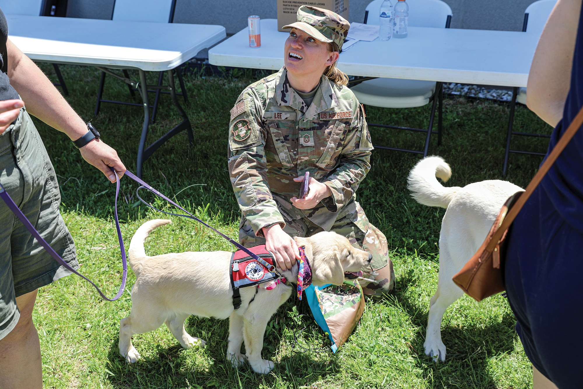 Master Sgt. Michelle Lee, 445th Aeromedical Staging Squadron, interacts with a service dog during a wing-wide wellness fair May 15, 2022, at Wright-Patterson Air Force Base, Ohio. The wellness fair gave Airmen an opportunity to socialize and obtain information about the various on-base and off-base helping agencies.
