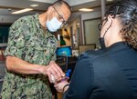 PORTSMOUTH, Va. (May 11, 2022) - Lt. Cmdr. Diego Londono, a Naval Medical Center Portsmouth (NMCP) chaplain, performs the "Blessing of the Hands" tradition on a nurse during Nurses Week. "The blessing of the hands is a moment of celebration and thanksgiving in recognition of the many moments nurses offer a personal healing touch to the patients they serve," said Capt. William Hlavin, NMCP command chaplain. (U.S. Navy photo by Mass Communication Specialist 2nd Class Dylan M. Kinee/Released)