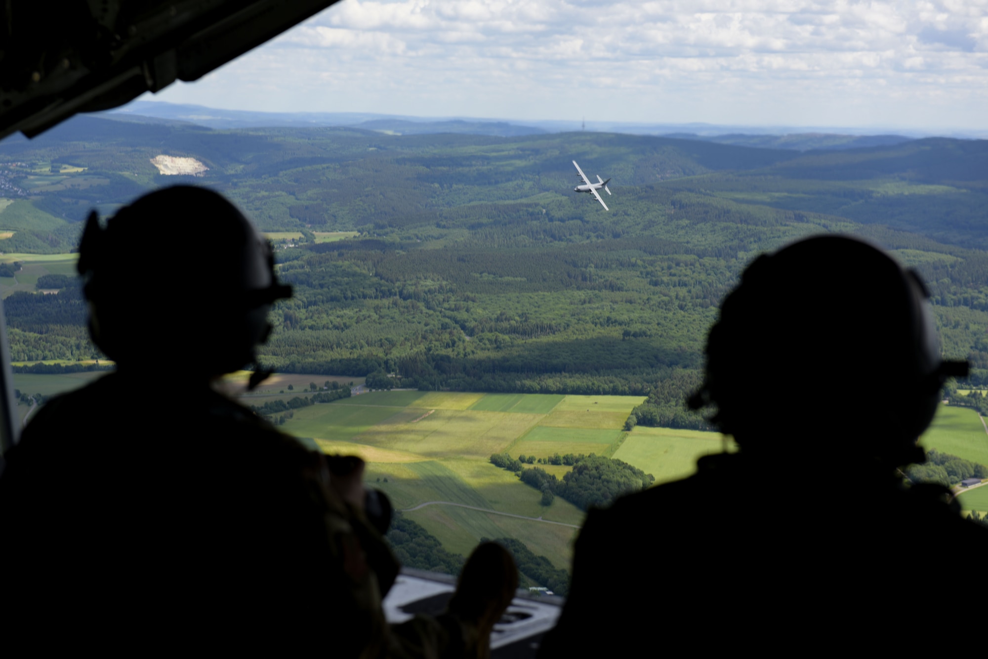 U.S. Air Force Staff Sgt. Megan Beatty (left), 86th Airlift Wing Public Affairs craftsman, and Tech. Sgt. John Huberty (right), 37th Airlift Squadron aircraft loadmaster, sit on the ramp of a C-130J Super Hercules aircraft