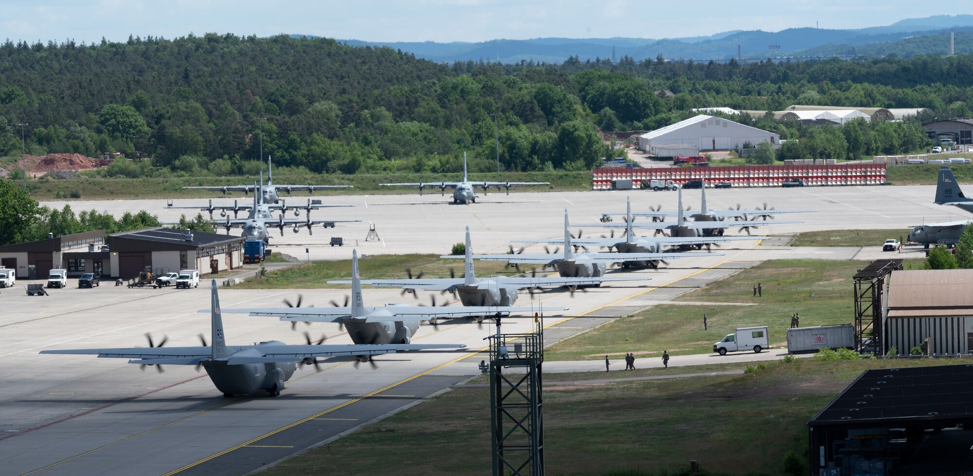 Nine C-130J Super Hercules aircraft taxi into formation
