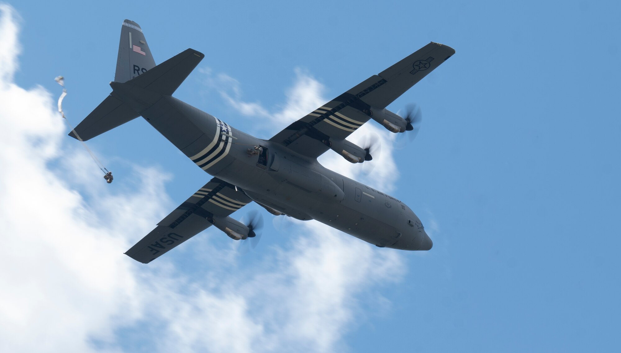 U.S. service members jump out of a C-130J Super Hercules aircraft