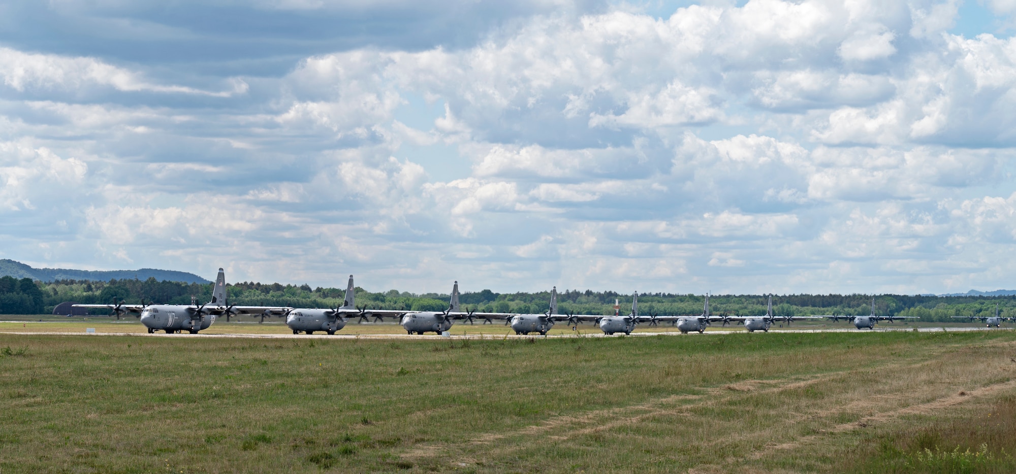 Several C-130 J Super Hercules aircraft line up on the flightline
