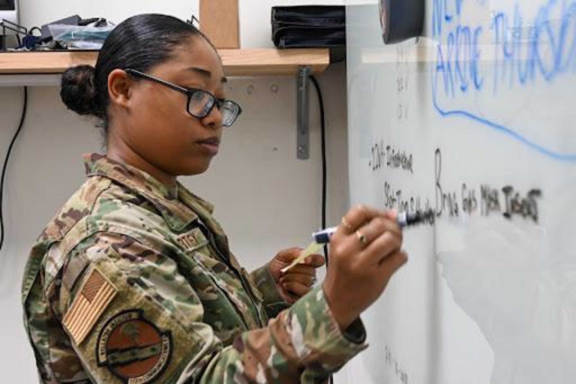Staff Sgt. Tiara Hartley, 113th Wing, D.C. Air National Guard, writes on a whiteboard as she tracks information related to her job as a Communications Focal Point representative.