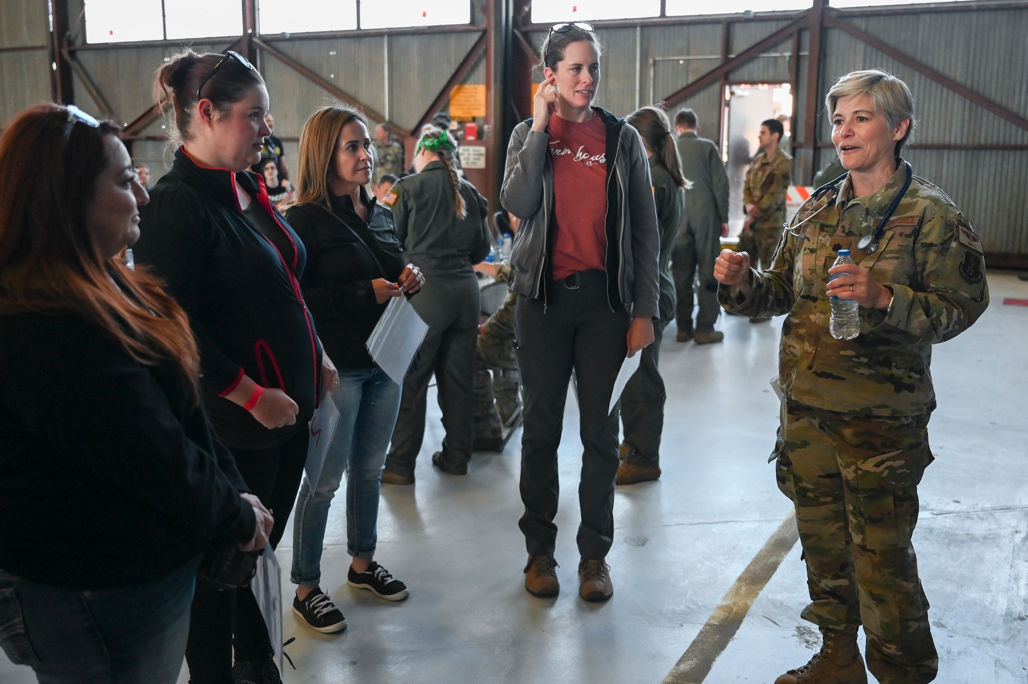 Family members of the 58th  and 150th Special Operations Wings get a safety briefing for Spouses Day event at Kirtland Air Force Base, New Mexico. May 14, 2022. Kirtland family helping agencies attended the spouse flight event displaying family readiness resources available to all 58th and 150th SOW military members and their families. (U.S. Air Force photo by Amn Tallon Bratton.)