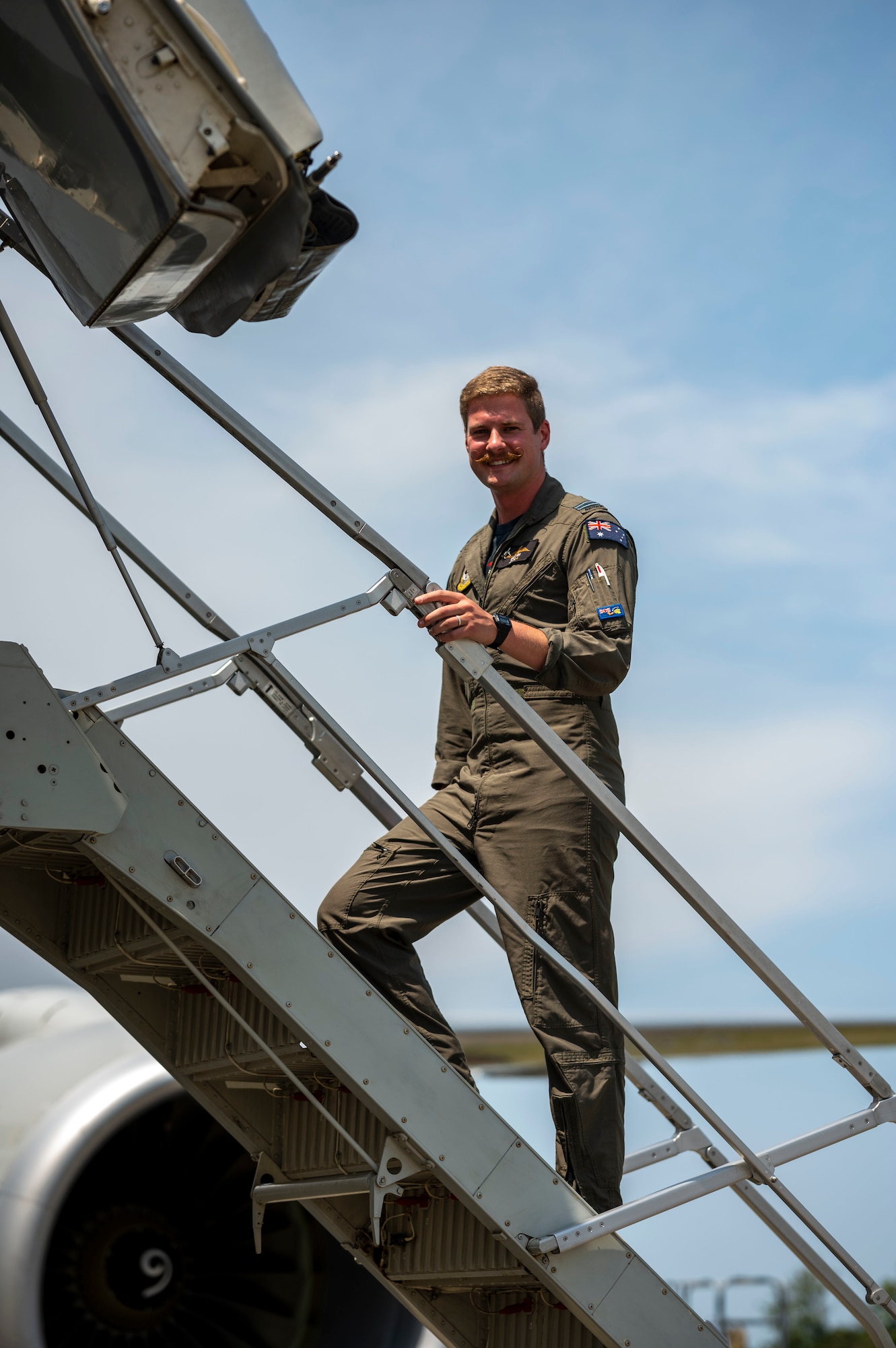 Australian military member walks up stairs into aircraft