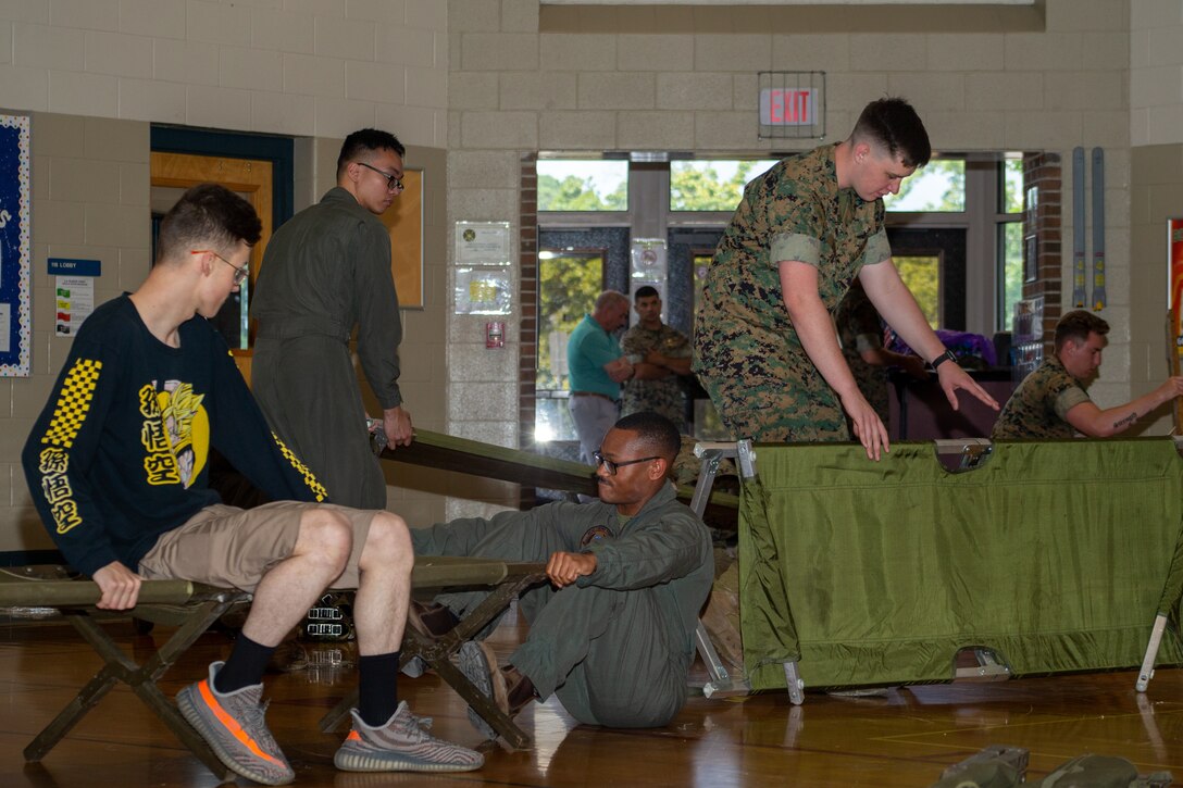 U.S. Marines, volunteers, and role-players break down cots during HURREX, a hurricane preparation exercise, inside the gymnasium at the Cherry Treehouse, Marine Corps Air Station (MCAS) Cherry Point, North Carolina, May 16, 2022. HURREX is a week-long hurricane preparedness exercise held across the installation that’s intended to increase MCAS Cherry Point’s readiness for Atlantic hurricane season . (U.S. Marine Corps photo by Lance Cpl. Lauralle Walker)
