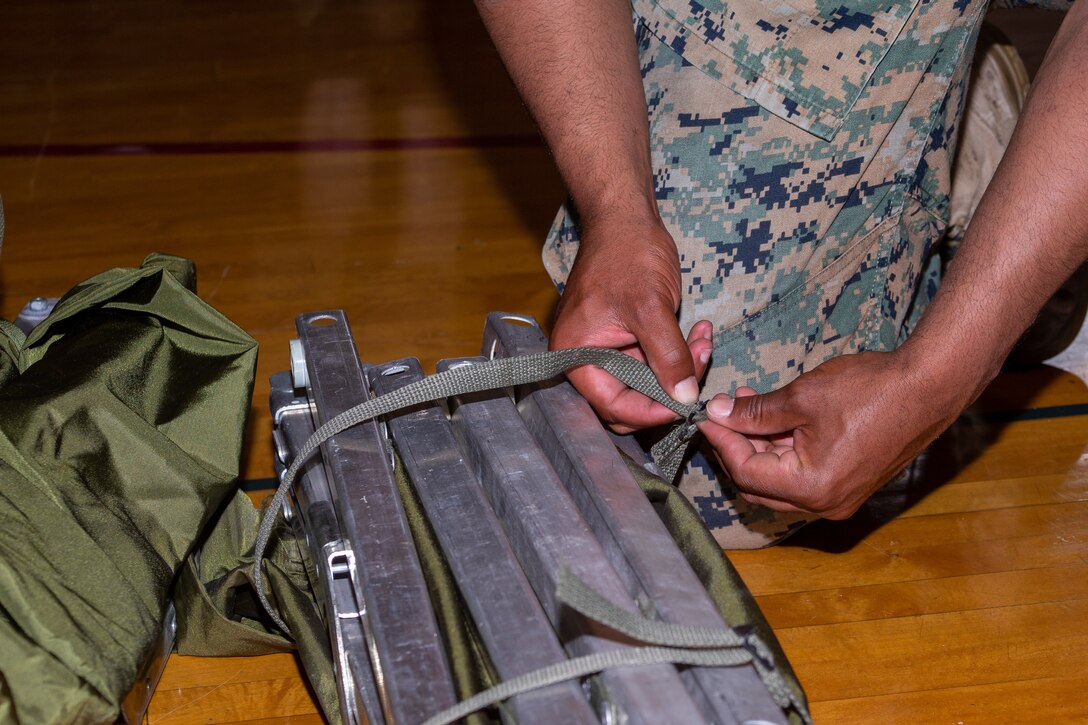 U.S.   Marine Corps Sgt. Tyrone Ball, a range coach assigned to Headquarters and Headquarters Squadron, Marine Corps Air Station (MCAS) Cherry Point, secures a cot as part of HURREX, MCAS Cherry Point, North Carolina, May 16, 2022. HURREX is a week-long hurricane preparedness exercise held across the installation that’s intended to increase MCAS Cherry Point’s readiness for Atlantic hurricane season. (U.S. Marine Corps photo by Lance Cpl. Lauralle Walker)