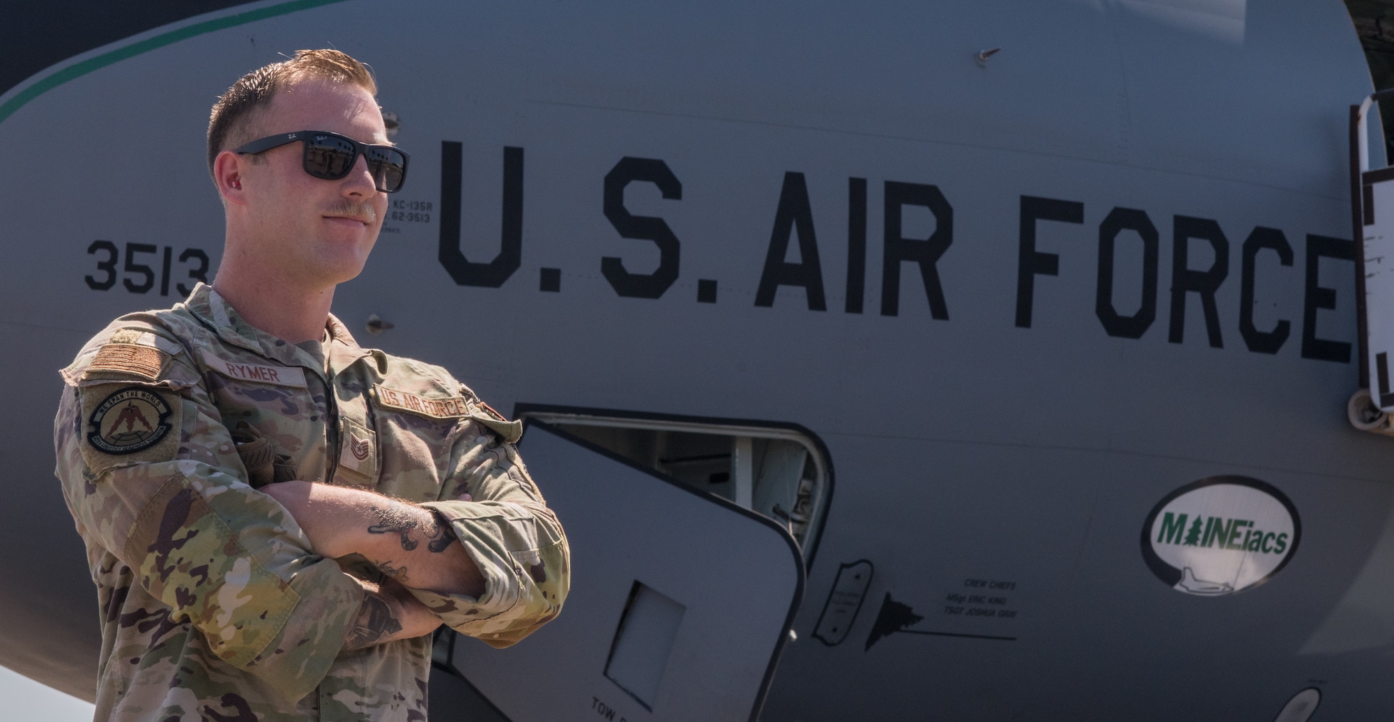 Military member posed for photo in front of an aircraft