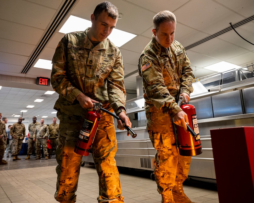 Two soldiers assigned to the Pennsylvania National Guard put their fire suppression training to the test on a fire extinguisher simulator while attending the 171st Air Refueling Wing Health and Safety AwarenessDay in Coraopolis, Pa. May 24, 2022.