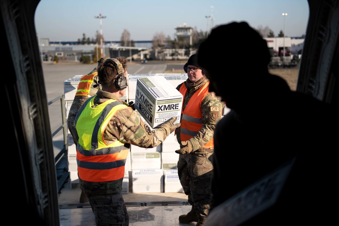 Airmen unload supplies from an aircraft.