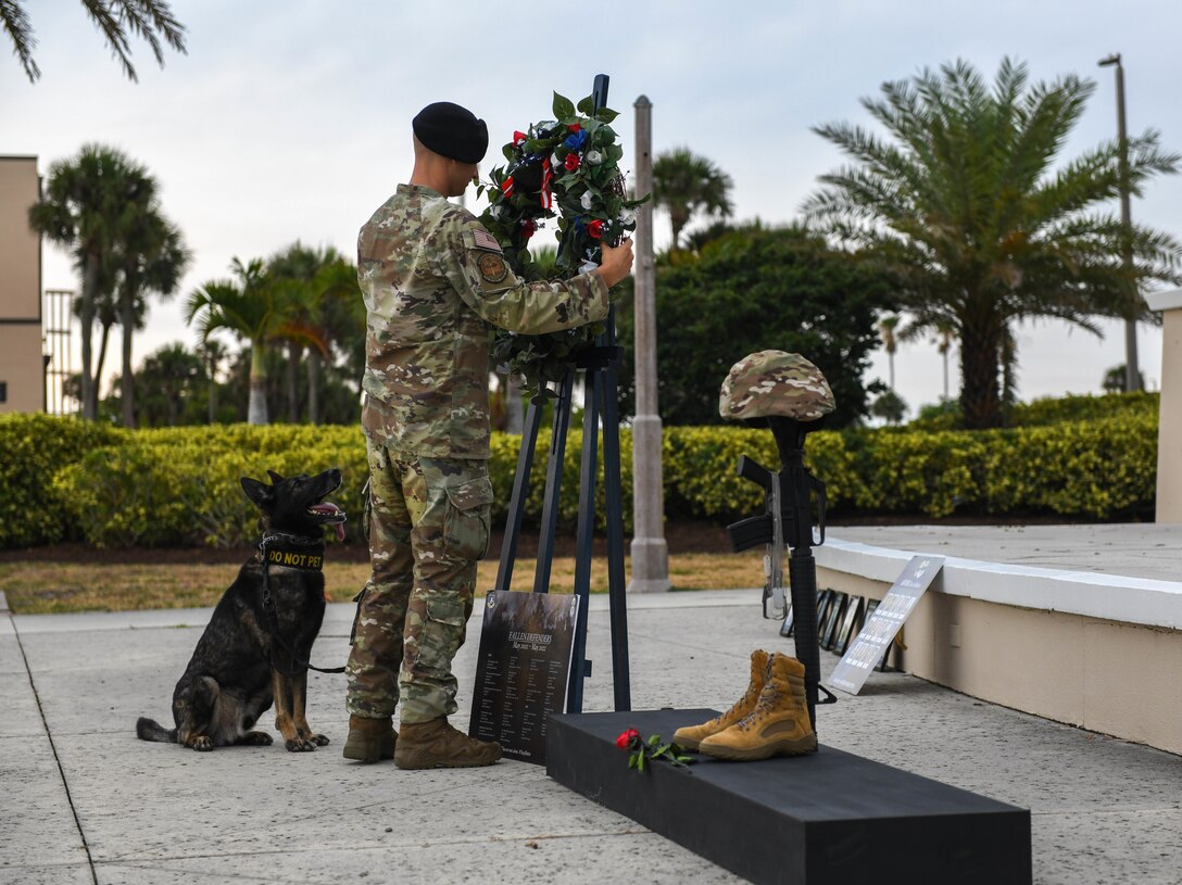 U.S. Air Force Staff Sgt. Joseph Pusich, 45th Security Forces Squadron military working dog handler, places a wreath on a stand during the fallen heroes ceremony May 20, 2022, at Patrick Space Force Base, Fla. The fallen hero ceremony represents and honors all of the fallen heroes who have lost their lives in the line of action. (U.S. Air Force photo by Airman 1st Class Samuel Becker)