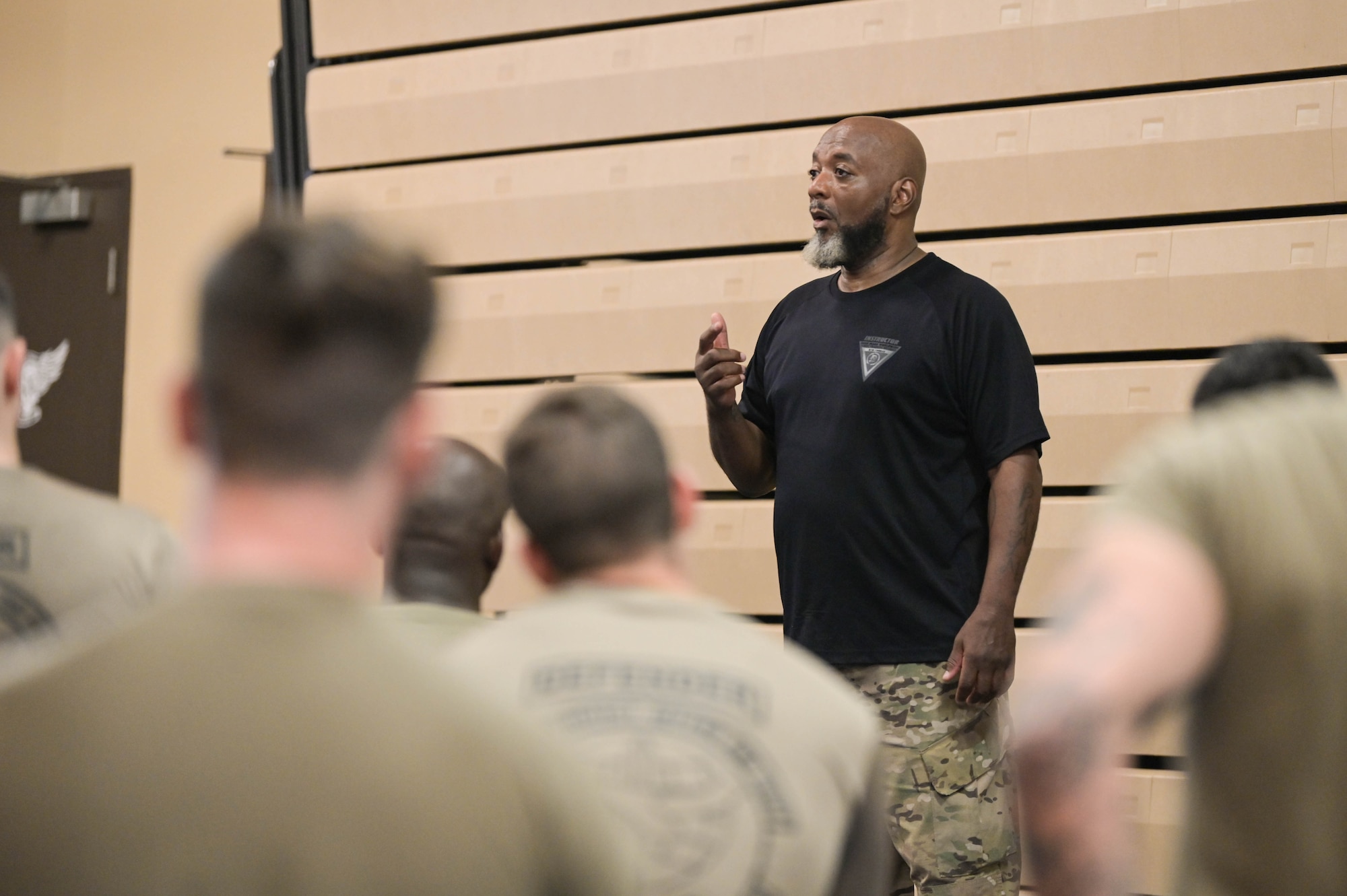 Bobby Cumby, retired security force defender and Office of Special Investigations agent, and Krav Maga instructor, addresses the 23rd Security Forces Squadron S3O-B2 “Thunder Cats” flight during the first iteration of Krav Maga training, April 13, 2022, at Moody Air Force Base, Georgia. Krav Maga is a more specific form of combative training to add to already known self-defense and weapons retention skills. (U.S. Air Force photo by Senior Airman Rebeckah Medeiros)