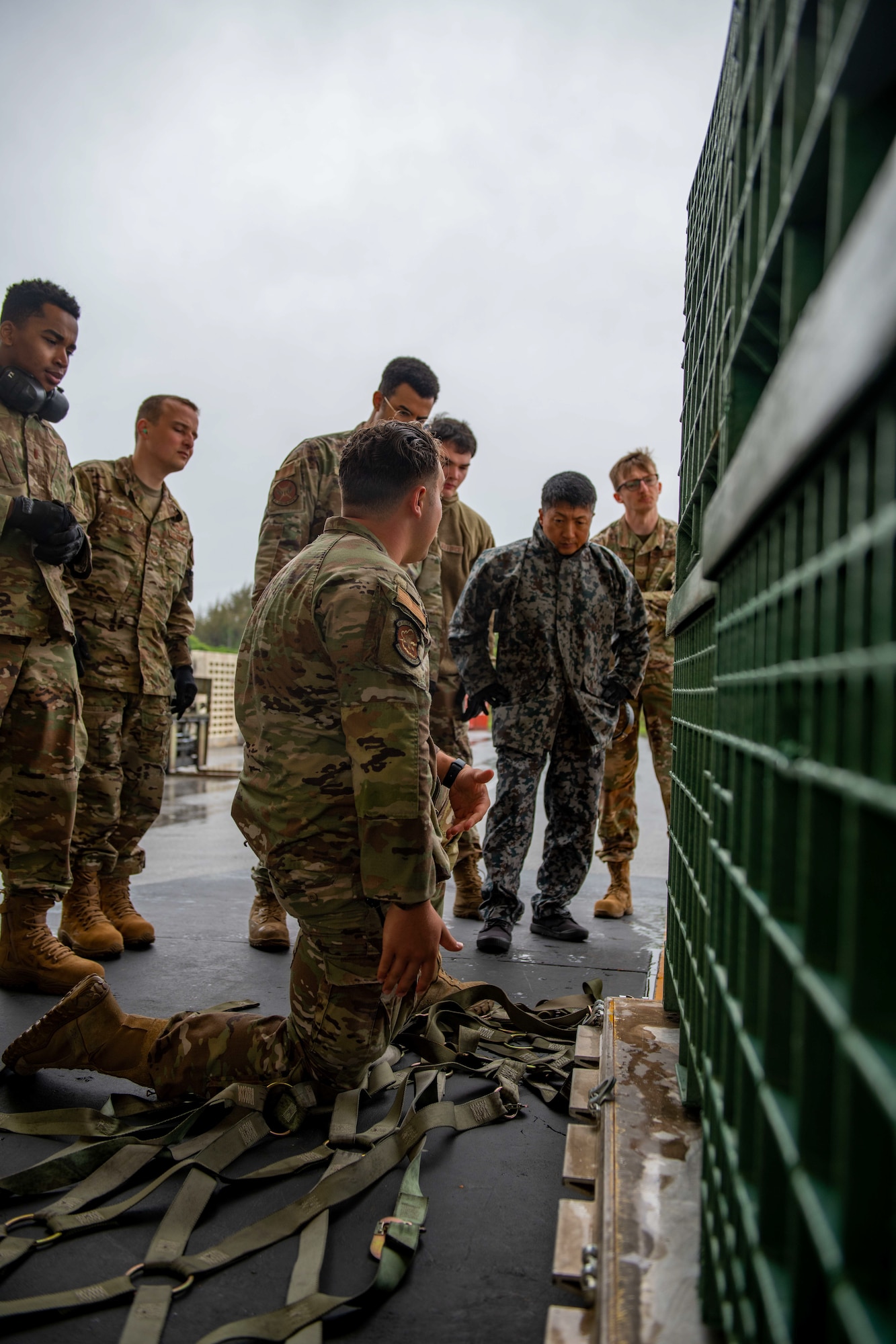 Airmen and a JASDF service member practice preparing cargo.