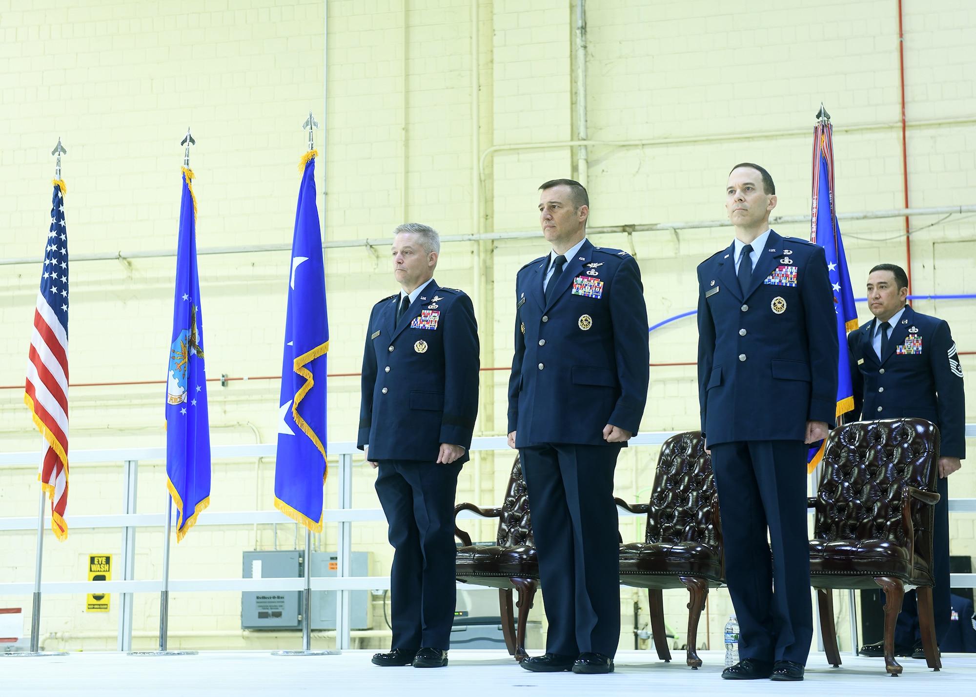 (L to R) Lt. Gen. Timothy Haugh, Sixteenth Air Force (Air Forces Cyber) commander, Col. Patrick Williams, outgoing 557th Weather Wing commander and Col. Bradley Stebbins, incoming 557 WW commander, Stand at attention as the colors are being flown and National Anthem is being performed on May 24, 2022 in hangar six on Offutt AFB.