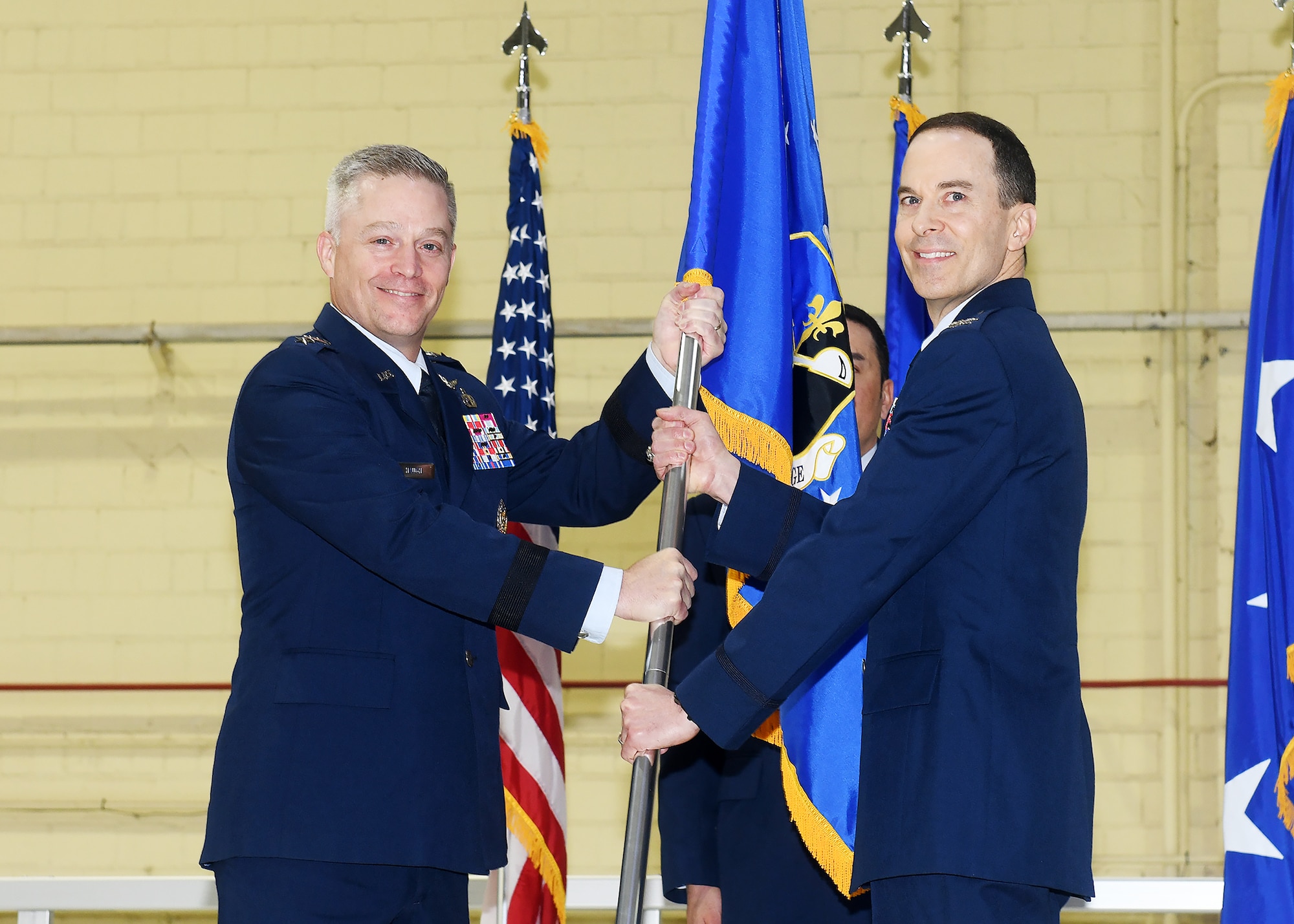 Lt. Gen. Timothy Haugh, Sixteenth Air Force (Air Forces Cyber) commander presents the guidon for the 557th Weather Wing to Col. Bradley Stebbins during a change of command ceremony on May 24, 2022 in hangar six on Offutt Air Force Base.