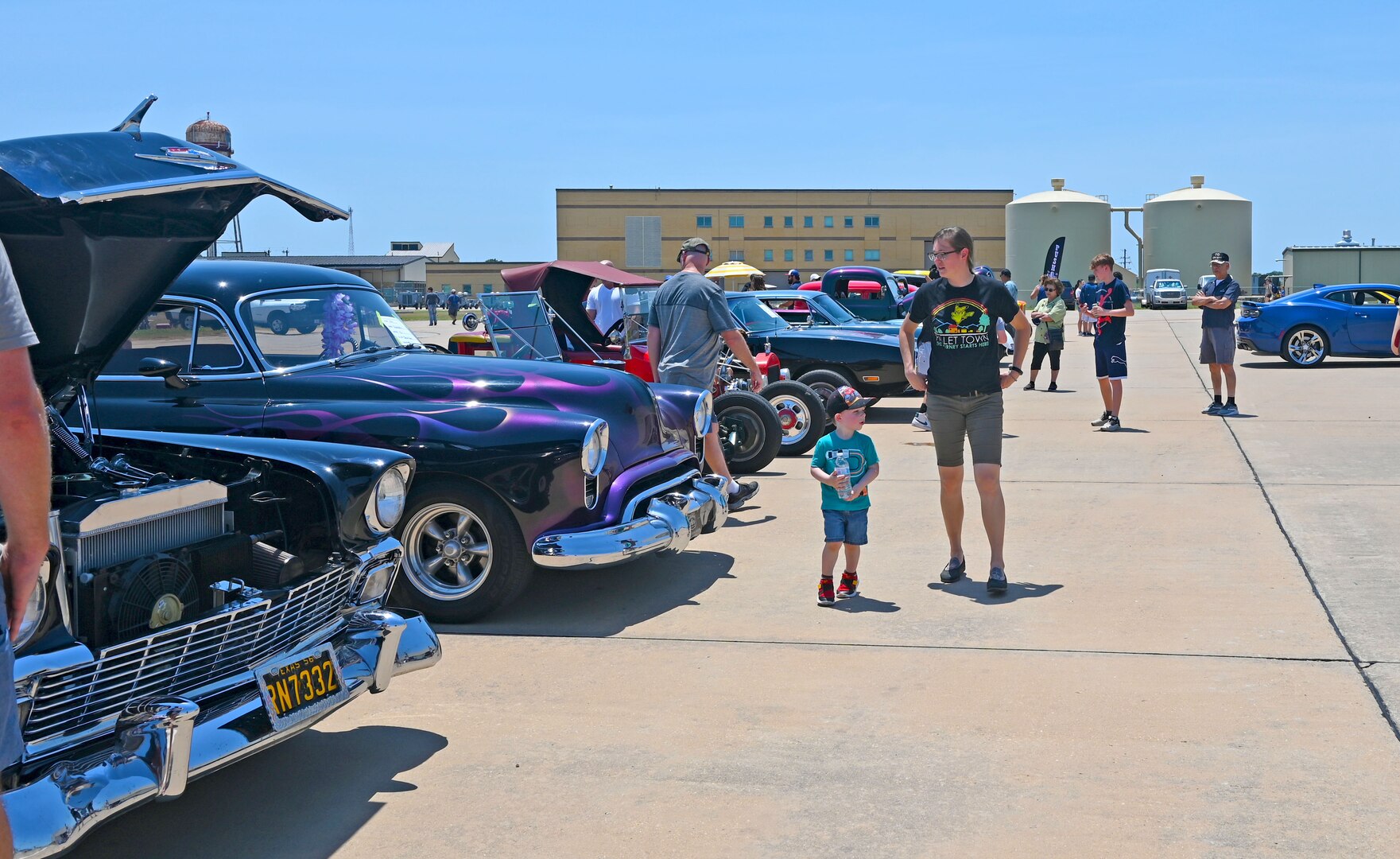 Reserve Citizen Airmen and their families enjoy a car show at the 2022 433rd Airlift Wing Family Day May 15, 2022, at Joint Base San Antonio-Lackland, Texas. This was the first family day event since 2019, due to the COVID-19 pandemic. (U.S. Air Force photo by Kristian Carter)