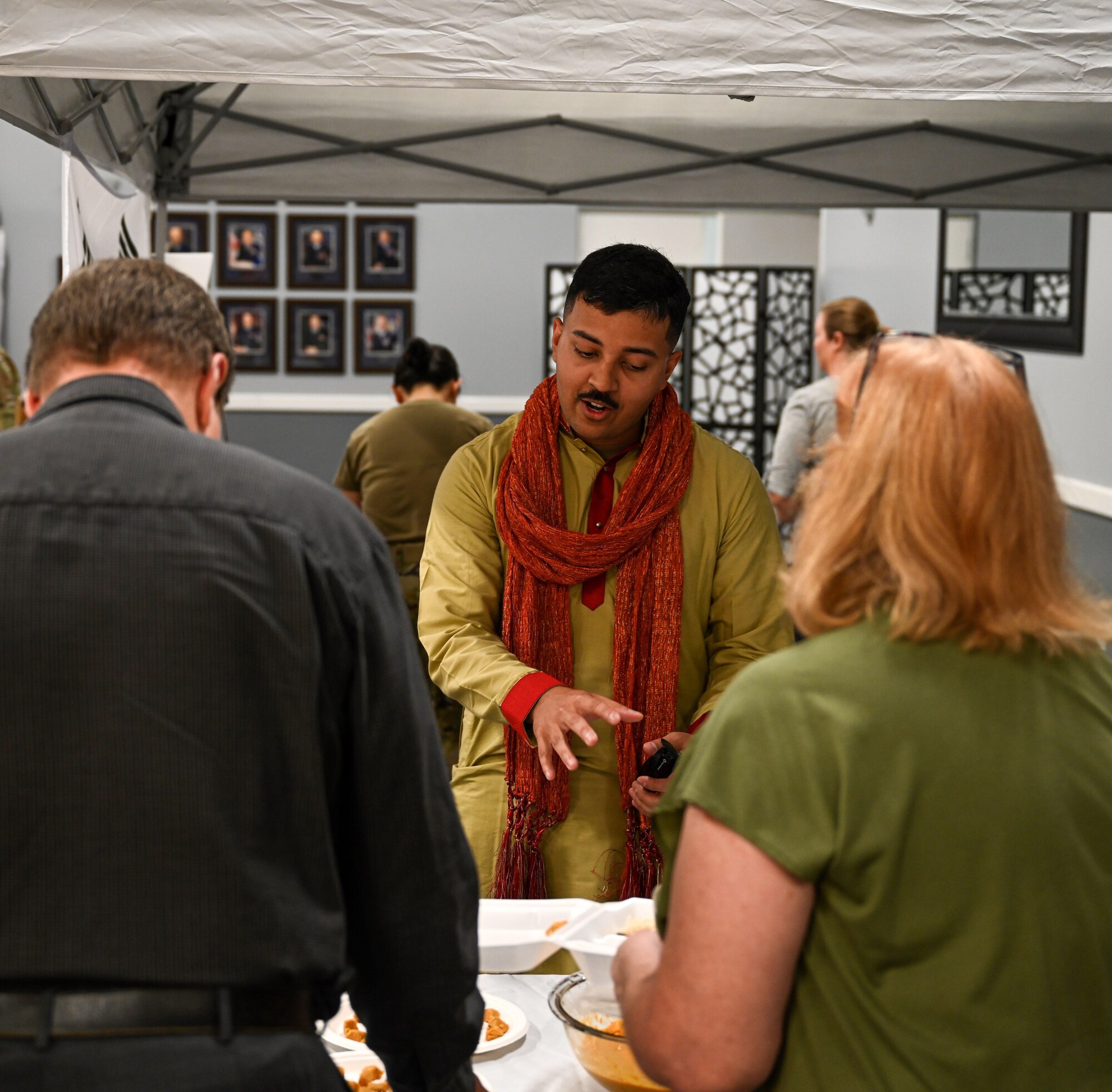 Second Lt. Ojas Parashar, 14th Mission Support Group financial service flight commander, explains various dishes native to Asian and Pacific Island countries on May 19, 2022, at Columbus Air Force Base, Miss. The observance took place at the Columbus Event Center and had multiple AAPI speakers. At the end, there was food available from various AAPI countries. (U.S. Air Force photo by Senior Airman Davis Donaldson)