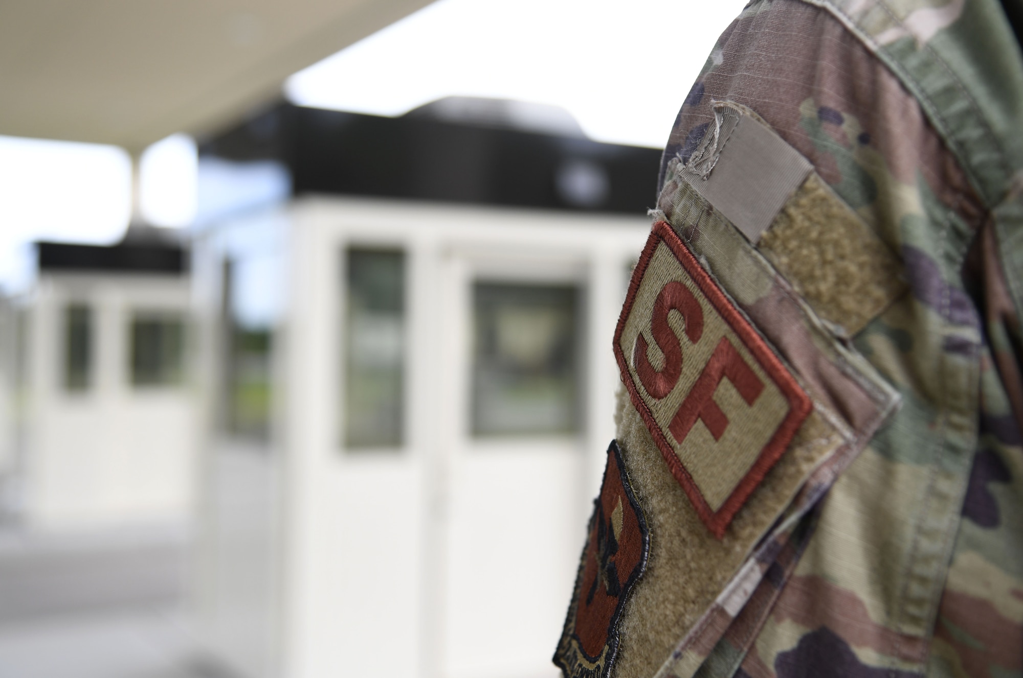 U.S. Air Force Senior Airman Garrett Jones, 81st Security Forces Squadron base defense operations center controller, stands guard during the Division Street Gate Ribbon Cutting Ceremony inside the Commercial Vehicle Inspection Building at Keesler Air Force Base, Mississippi, May 26, 2022. After approximately two years of construction, Keesler's new main gate marks the completion of a multi-sourced and multi-funded project which will enhance force protection and anti-terrorism measures. Keesler partnered with the city of Biloxi, along with state and federal planners, to align the primary entrance at Division Street. (U.S. Air Force photo by Kemberly Groue)