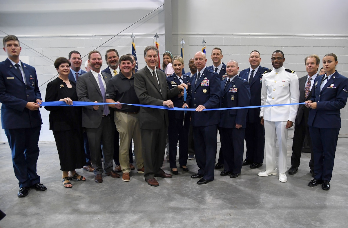 Keesler leadership and Mississippi state and local government officials pose for a photo during the Division Street Gate Ribbon Cutting Ceremony inside the Commercial Vehicle Inspection Building at Keesler Air Force Base, Mississippi, May 26, 2022.