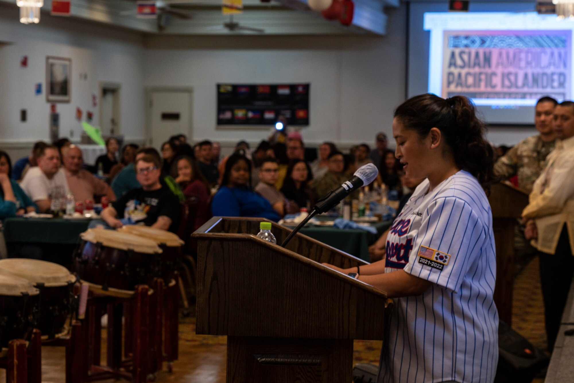 A female Airman delivers a speech about Asian American and Pacific Islander Heritage.