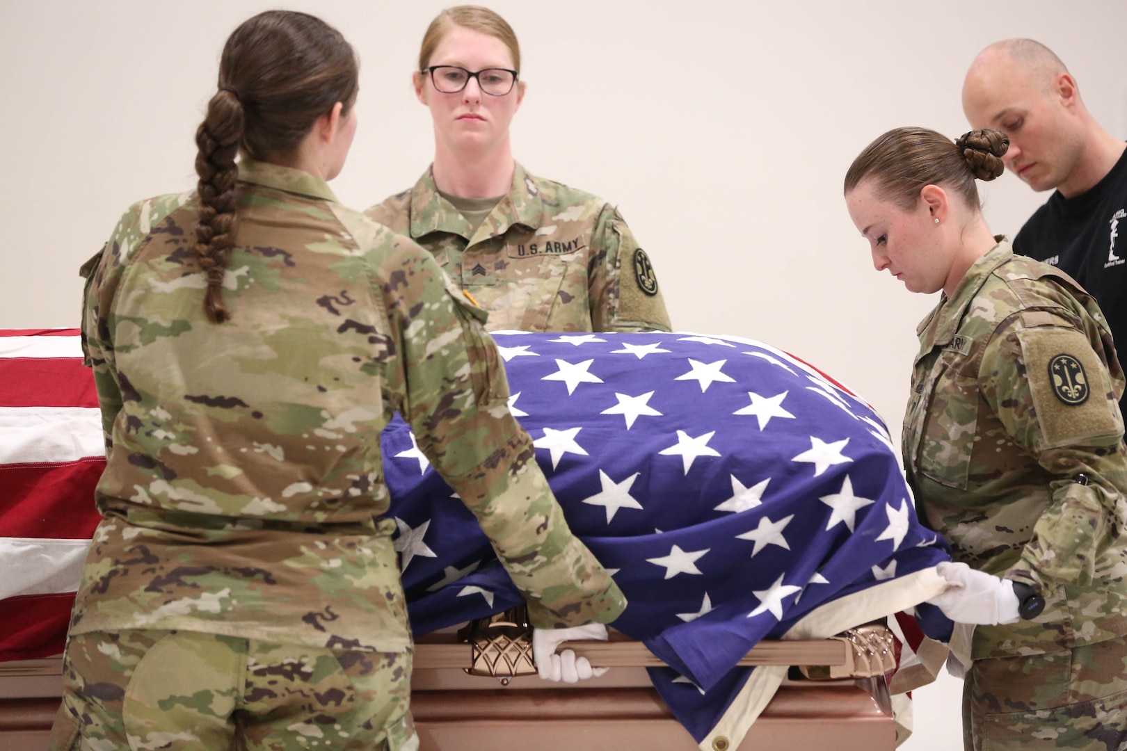 Soldiers prepare a flag covered coffin for movement
