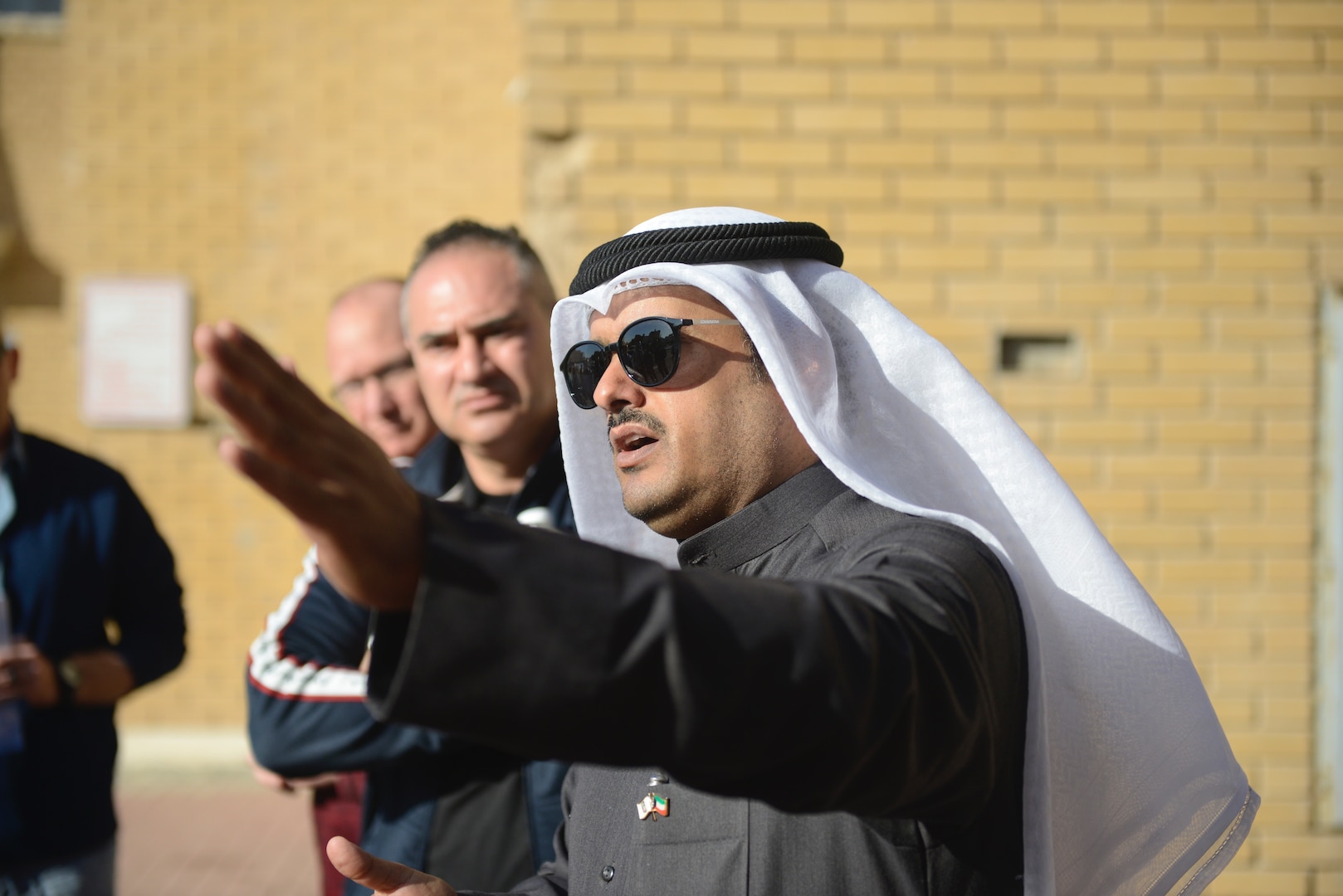 Image of a man with a turbin in conversation with other men.