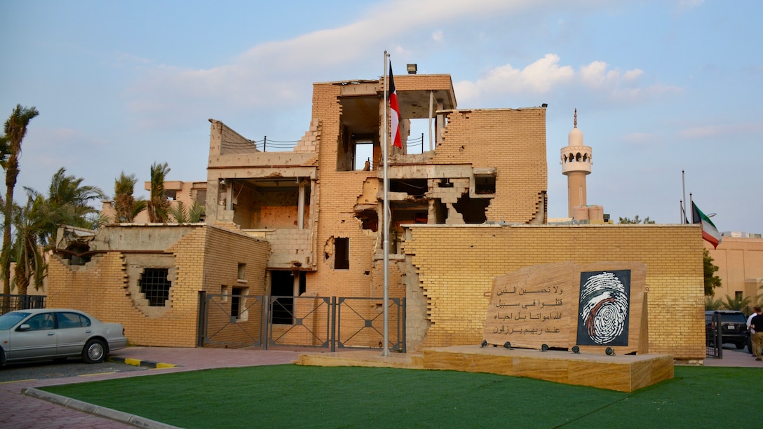 Image of a broken building with a flag and a car.