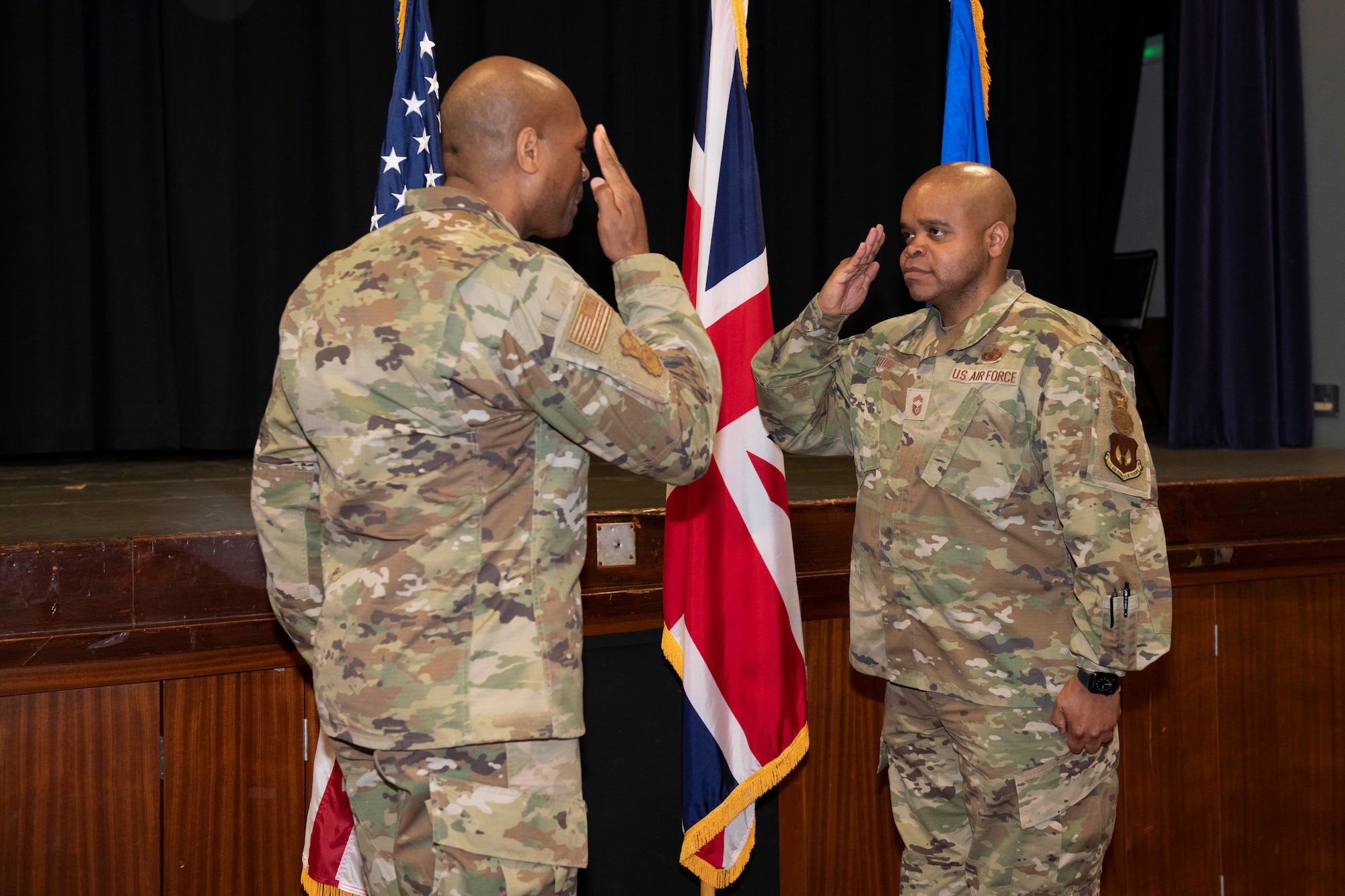 U.S. Air Force Brig. Gen. Roy W. Collins, left, Headquarters U.S. Air Force director of security forces and deputy chief of staff for logistics, engineering and force protection, recognizes Chief Master Sgt. Cleophus Gallon, right, 422nd Security Forces Squadron senior enlisted leader, during a visit to Royal Air Force Croughton, England, May 23, 2022. Collins and Chief Master Sgt. Donald S. Gallagher, 20th Security Forces career field manager, visited RAF Croughton to present the 2021 Air Force Best Small Security Forces Squadron to the 422nd SFS. (U.S. Air Force photo by Senior Airman Jennifer Zima