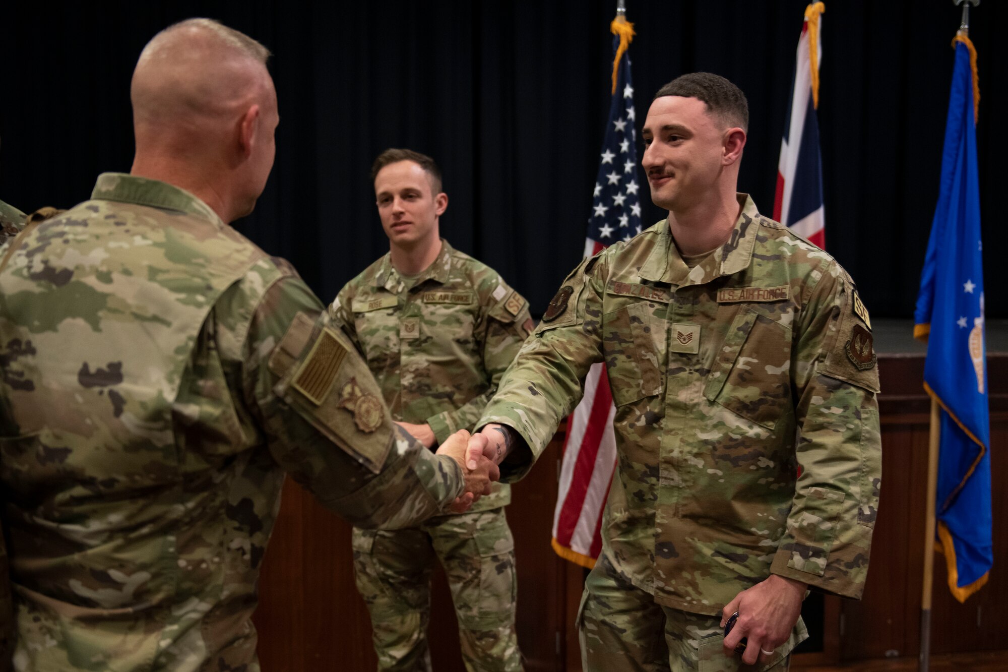 U.S. Air Force Chief Master Sgt. Donald S. Gallagher, left, 20th Security Forces career field manager, recognizes Staff Sgt. Jesus Gonzalez Jr., right, 422nd Security Forces Squadron flight sergeant, during a visit to Royal Air Force Croughton, England, May 23, 2022. Gallagher and Brig. Gen. Roy W. Collins, Headquarters U.S. Air Force director of security forces and deputy chief of staff for logistics, engineering and force protection, visited RAF Croughton to present the 2021 Air Force Best Small Security Forces Squadron to the 422nd Security Forces Squadron. (U.S. Air Force photo by Senior Airman Jennifer Zima)