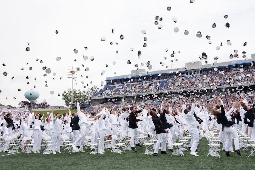 U.S. Naval Academy graduates toss their covers in the air.