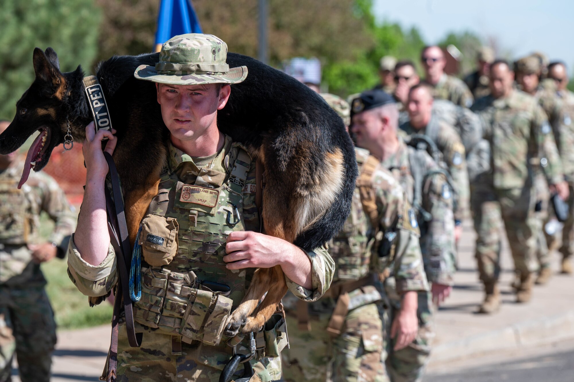 Senior Airman Seth Vreeland, a K-9 handler with the 460th Security Forces Squadron, carries Military Working Dog Ketty