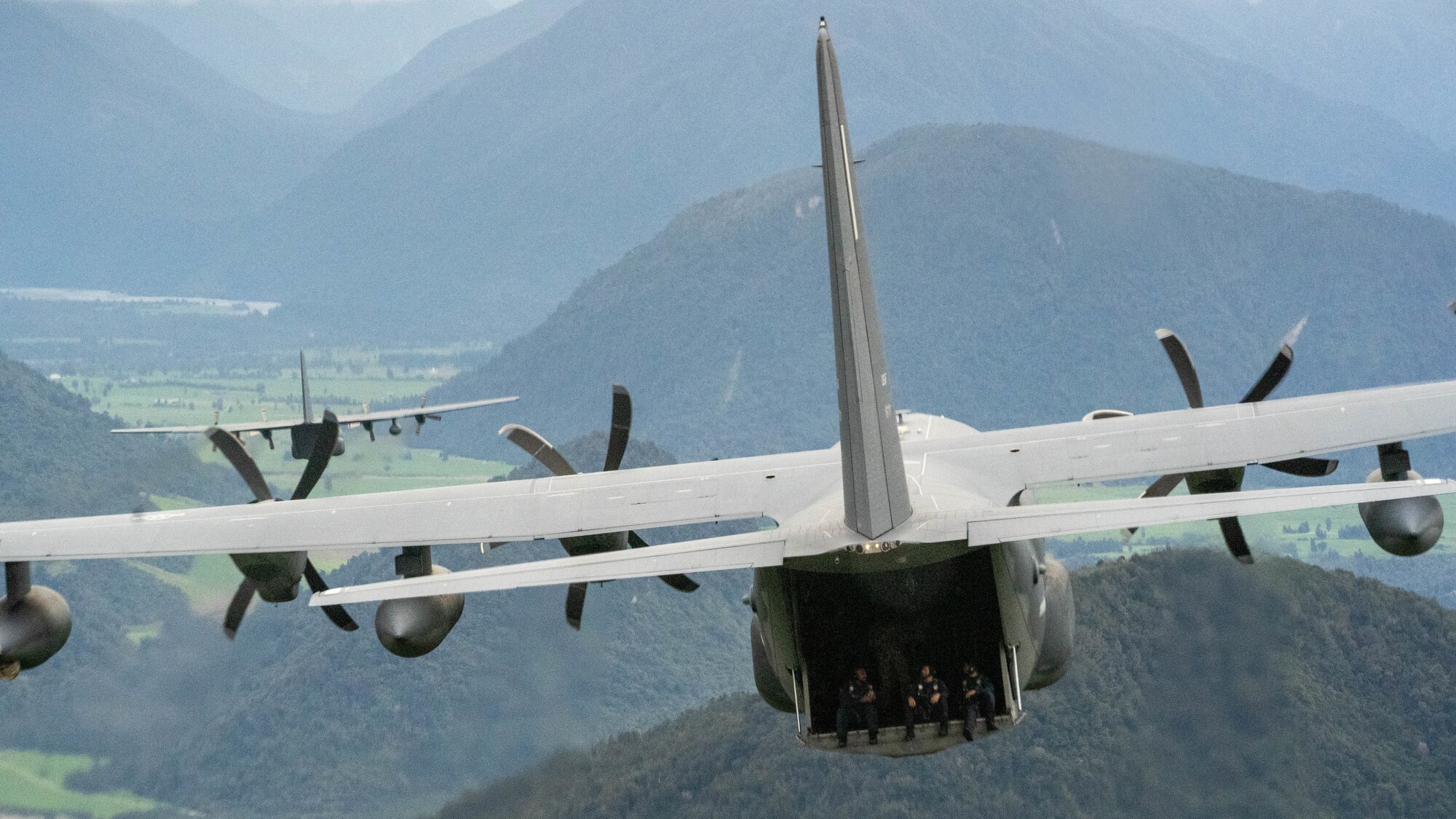 Members of the Royal New Zealand Air Force’s 40 Squadron observe their surroundings from the open ramp of a U.S. Air Force MC-130J Commando II