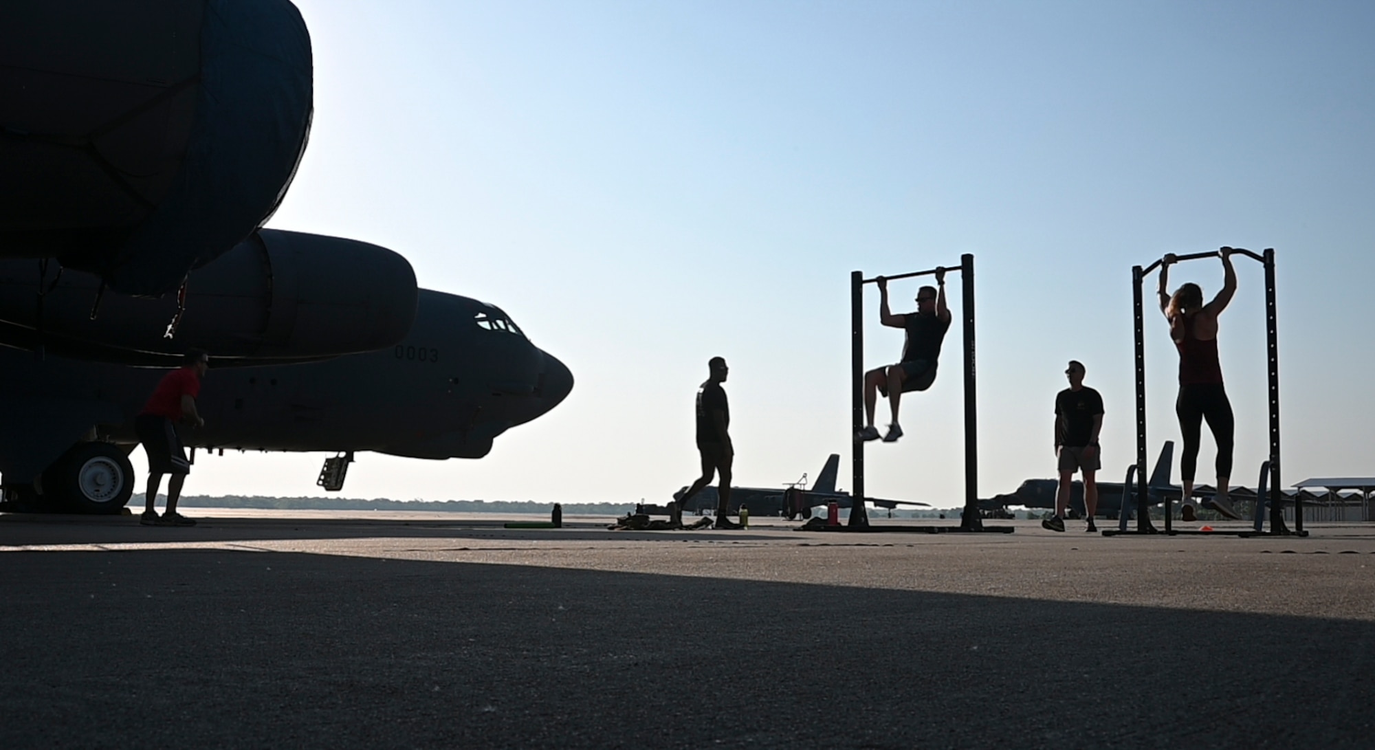 Silhoutte of B-52 and Airmen doing pullups