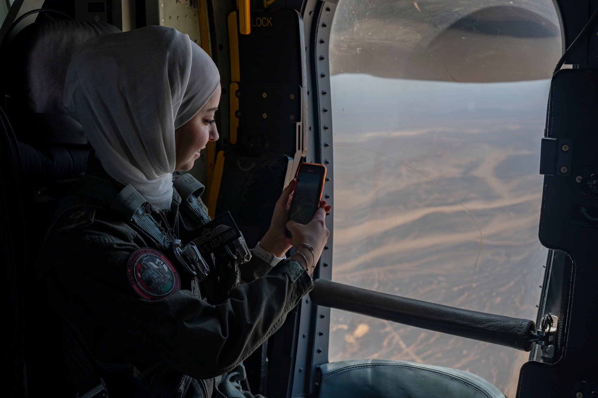 Lieutenant Lujain Abu-Rumman, Royal Jordanian Air Force Super Puma pilot, takes a photo from a window of a U.S. Air Force HC-130J Combat King II aircraft during a low-level mission over outlying areas of Wadi Rum, Jordan on May 16, 2022. The engagement is part of an ongoing partnership between the two countries focused on empowering women in aviation as a way to cultivate and strengthen relationships. (U.S. Air Force photo by Master Sgt. Kelly Goonan)