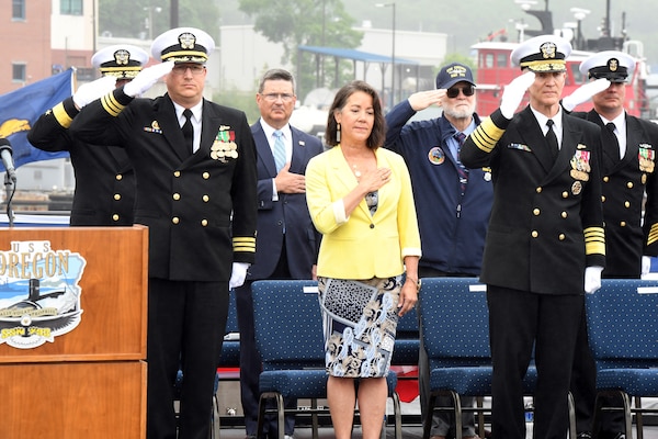 Dana Richardson, ship sponsor for the Virginia-class submarine USS Oregon (SSN 793), honors the colors alongside Oregon’s commanding officer Cmdr. Lacy Lodmell, and Adm. Frank Caldwell, director of the Naval Nuclear Propulsion Program, during a commissioning ceremony in Groton, Conn., May 28, 2022.